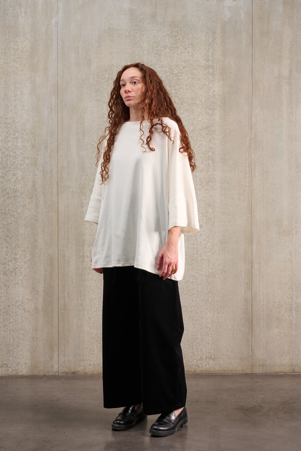 T-shirt oversize à col bateau de la marque Aïdama, modèle Haku en jersey de coton blanc certifié GOTS. Porté par une mannequin femme et vu de trois quarts.