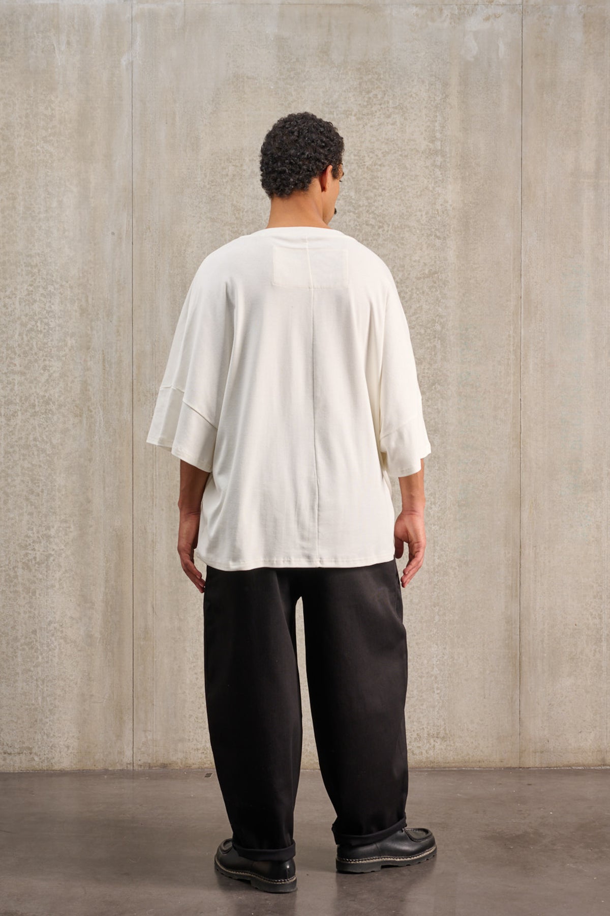 T-shirt oversize à col bateau de la marque Aïdama, modèle Haku en jersey de coton blanc certifié GOTS. Porté par un mannequin homme et vu de dos.