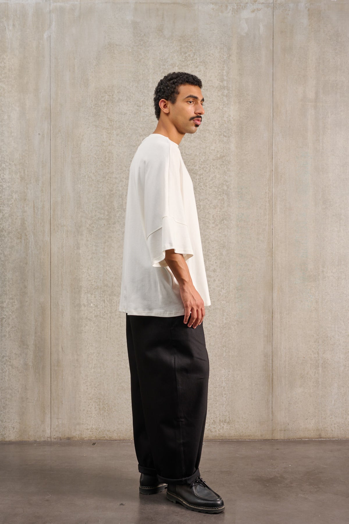 T-shirt oversize à col bateau de la marque Aïdama, modèle Haku en jersey de coton blanc certifié GOTS. Porté par un mannequin homme et vu de profil.