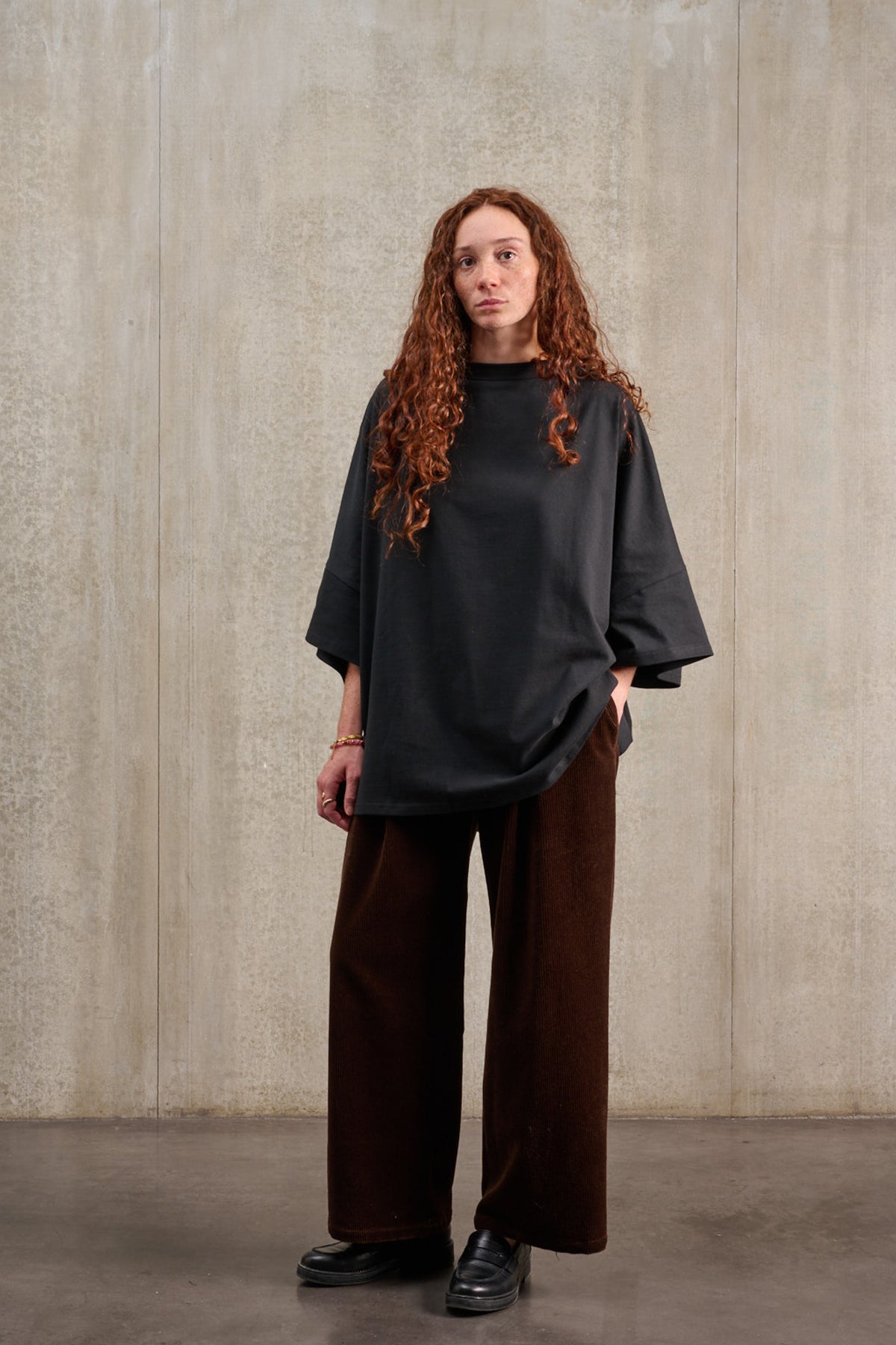 T-shirt oversize à col bateau de la marque Aïdama, modèle Haku en jersey de coton noir épais. Porté par une mannequin femme et vu de face.