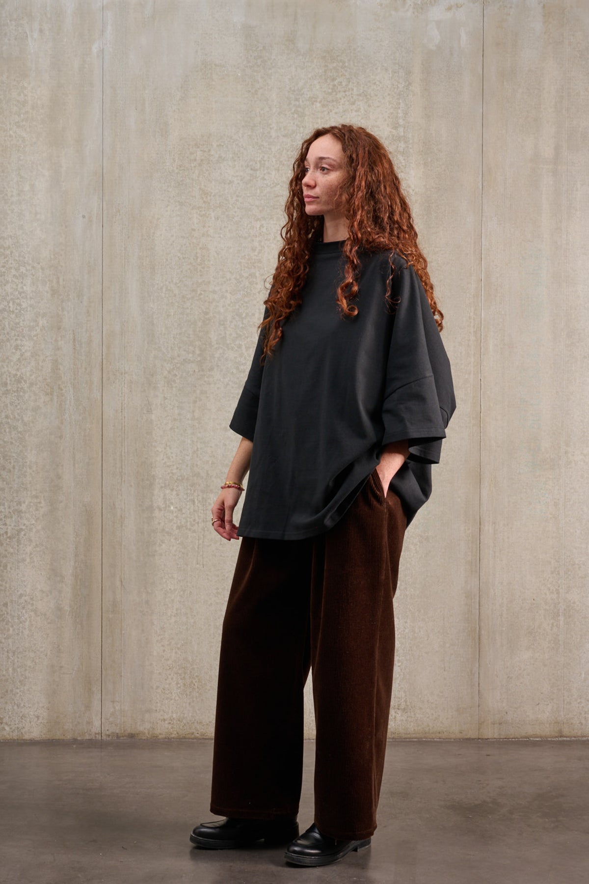 T-shirt oversize à col bateau de la marque Aïdama, modèle Haku en jersey de coton noir épais. Porté par une mannequin femme et vu de trois quarts.
