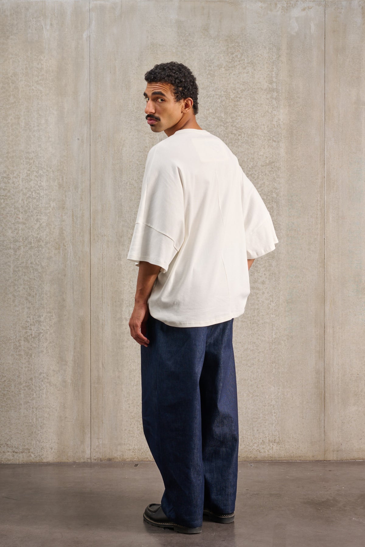 T-shirt oversize à col rond de la marque Aïdama, modèle Haku en jersey de coton blanc GOTS. Porté par un mannequin homme et vu de dos.