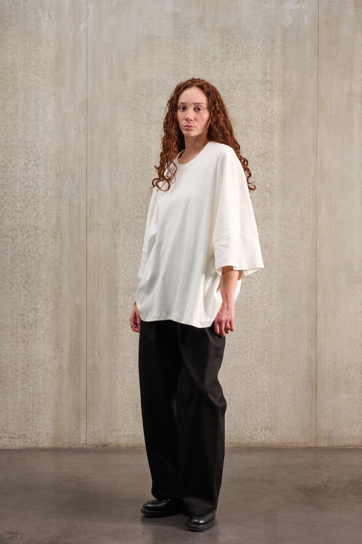 T-shirt oversize à col rond de la marque Aïdama, modèle Haku en jersey de coton blanc GOTS. Porté par une mannequin femme et vue de trois quarts.