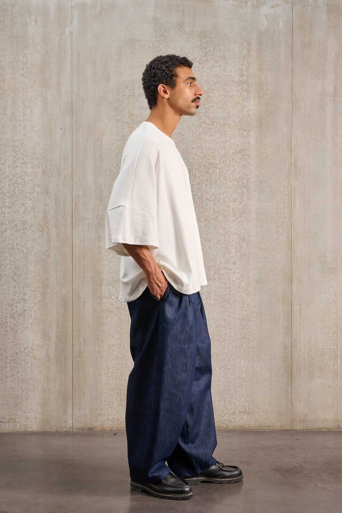 T-shirt oversize à col rond de la marque Aïdama, modèle Haku en jersey de coton blanc GOTS. Porté par un mannequin homme et vue de profil.