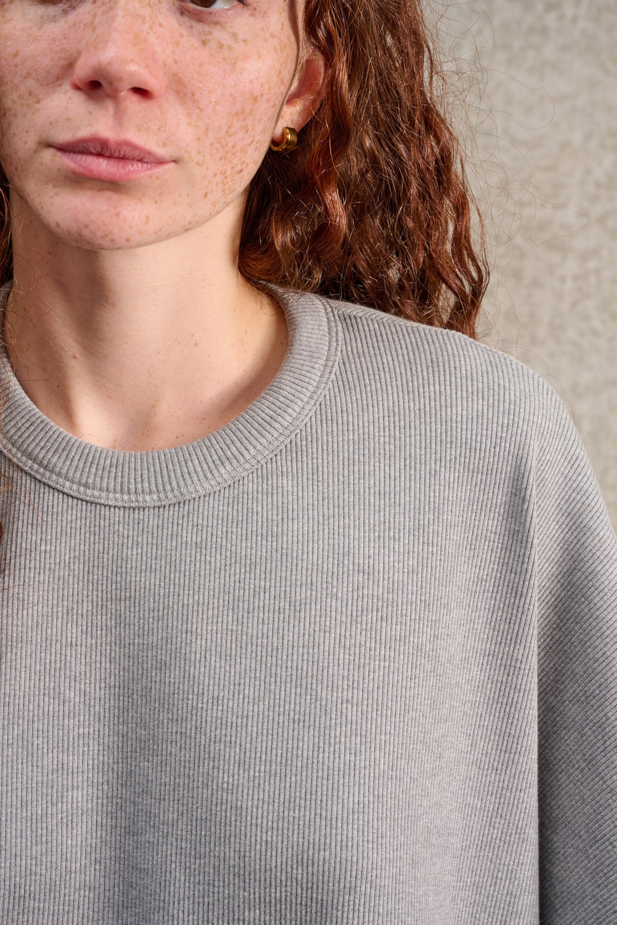 T-shirt oversize à col rond de la marque Aïdama, modèle Haku en jersey côtelé de coton gris chiné. Porté par une mannequin femme et vu zoomé sur le col.