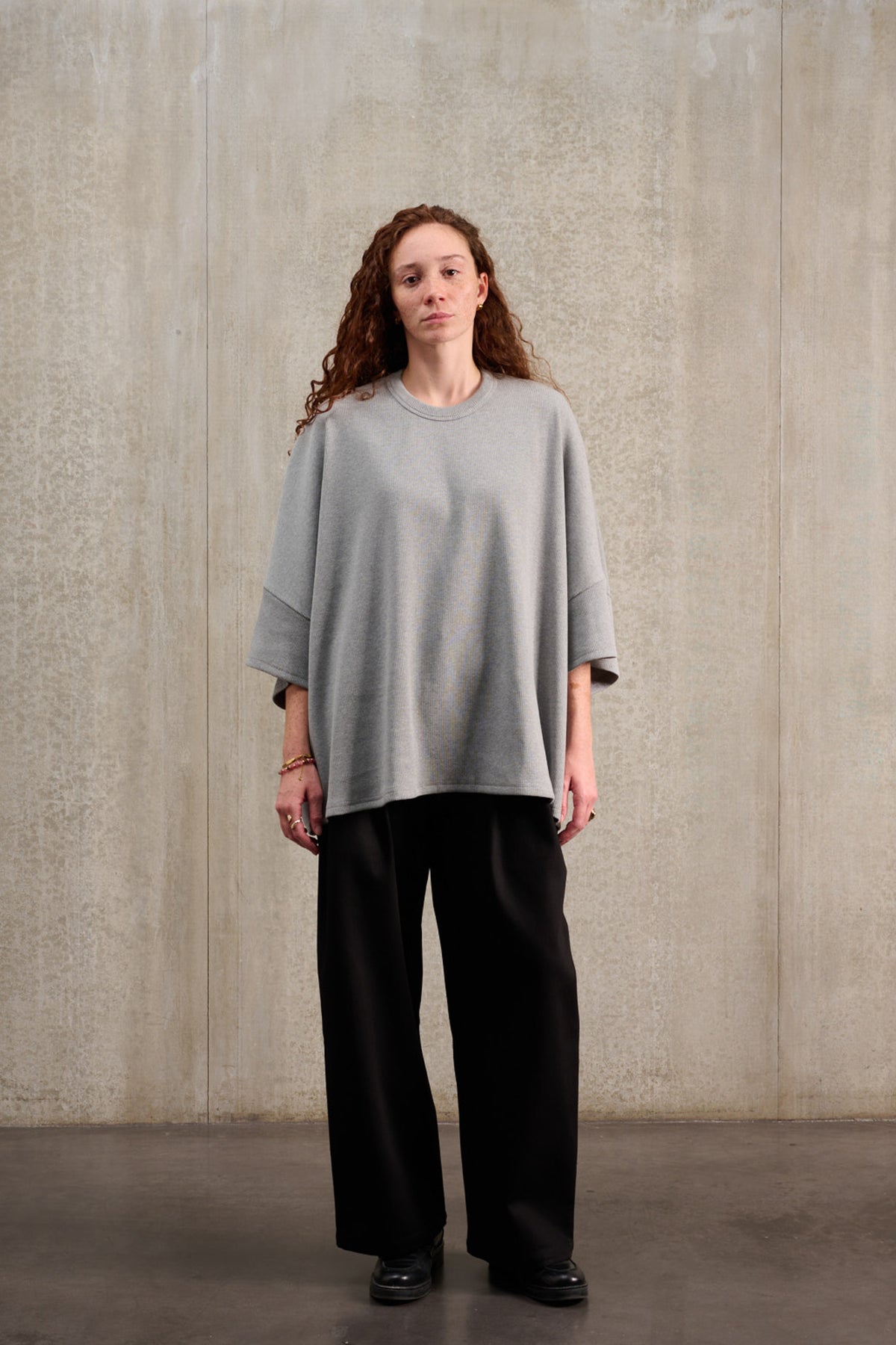 T-shirt oversize à col rond de la marque Aïdama, modèle Haku en jersey côtelé de coton gris chiné. Porté par une mannequin femme et vu de face.