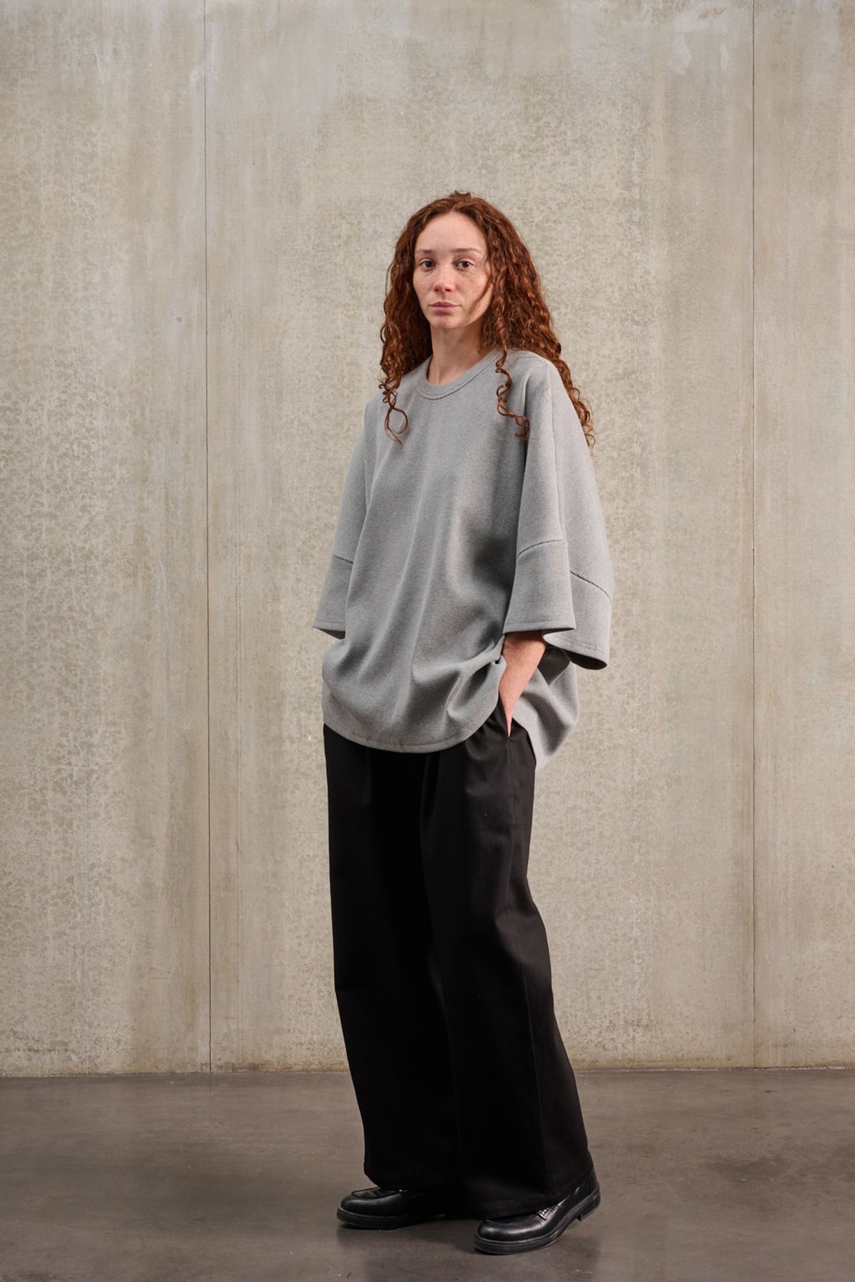 T-shirt oversize à col rond de la marque Aïdama, modèle Haku en jersey côtelé de coton gris chiné. Porté par une mannequin femme et vu de trois quarts.