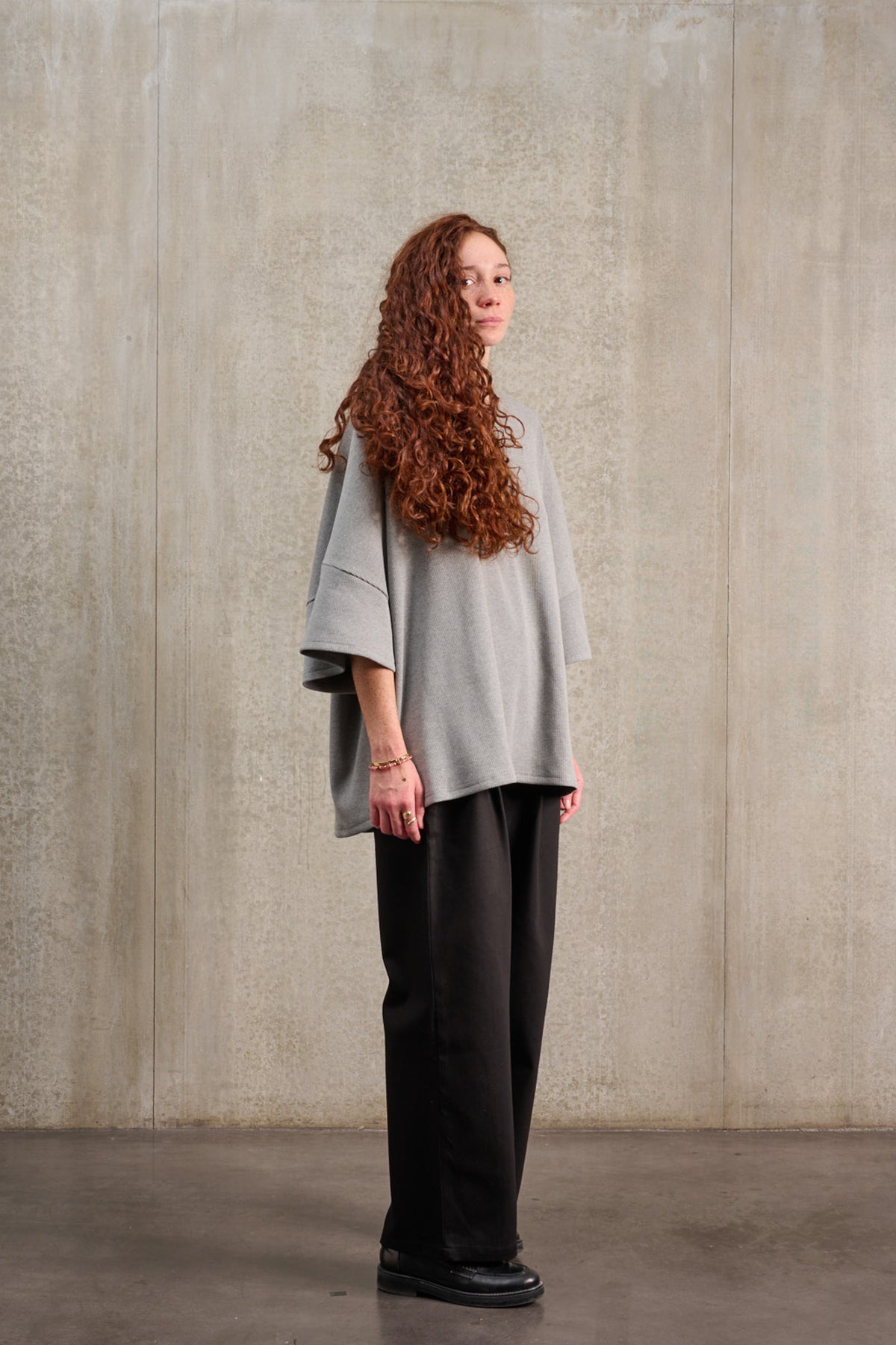 T-shirt oversize à col rond de la marque Aïdama, modèle Haku en jersey côtelé de coton gris chiné. Porté par une mannequin femme et vu de trois quarts.