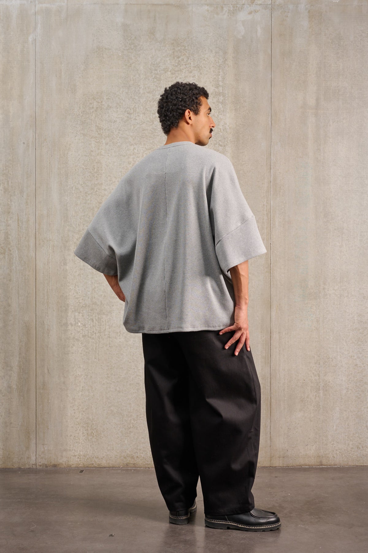 T-shirt oversize à col rond de la marque Aïdama, modèle Haku en jersey côtelé de coton gris chiné. Porté par un mannequin homme et vu de dos.