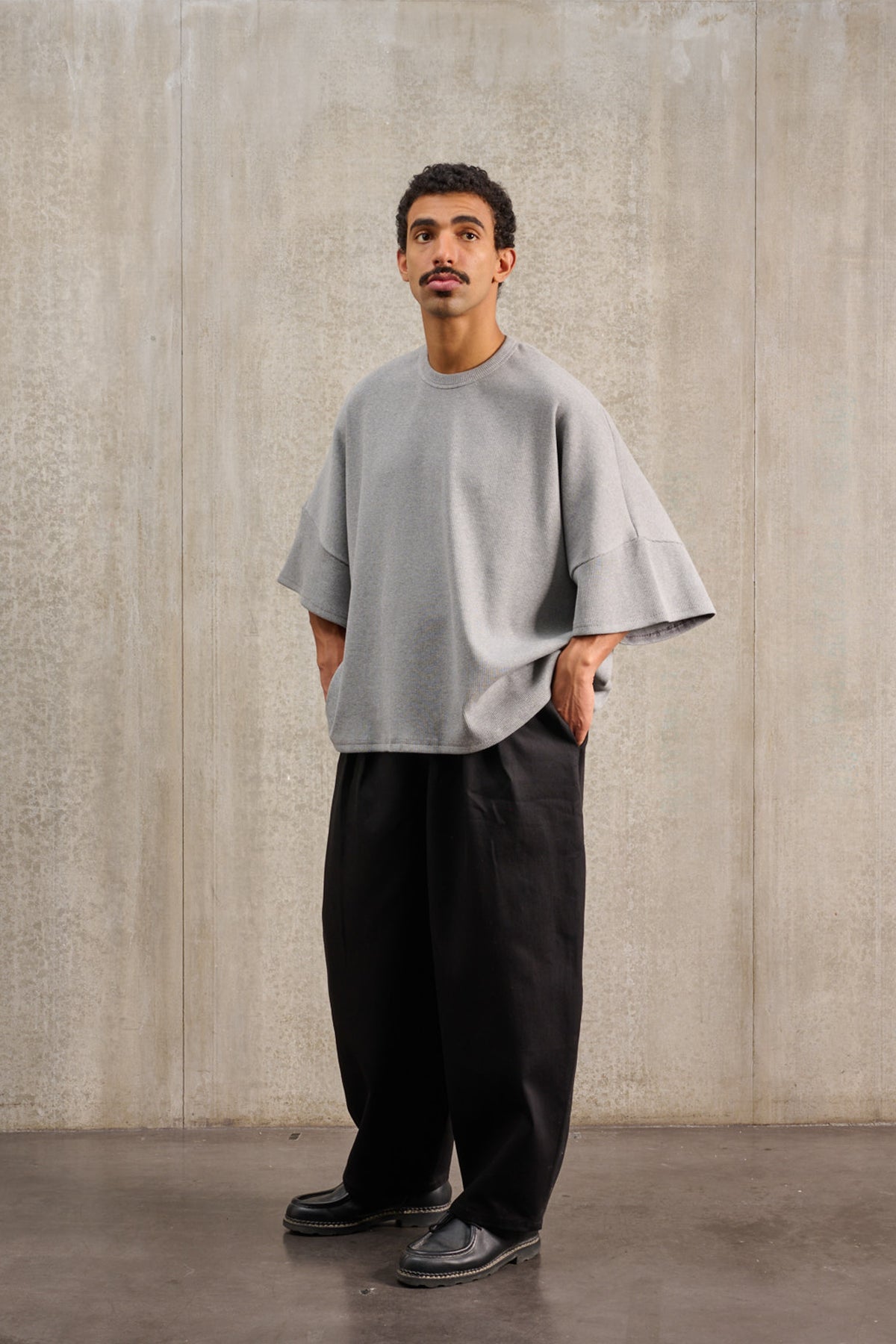 T-shirt oversize à col rond de la marque Aïdama, modèle Haku en jersey côtelé de coton gris chiné. Porté par un mannequin homme et vu de face.