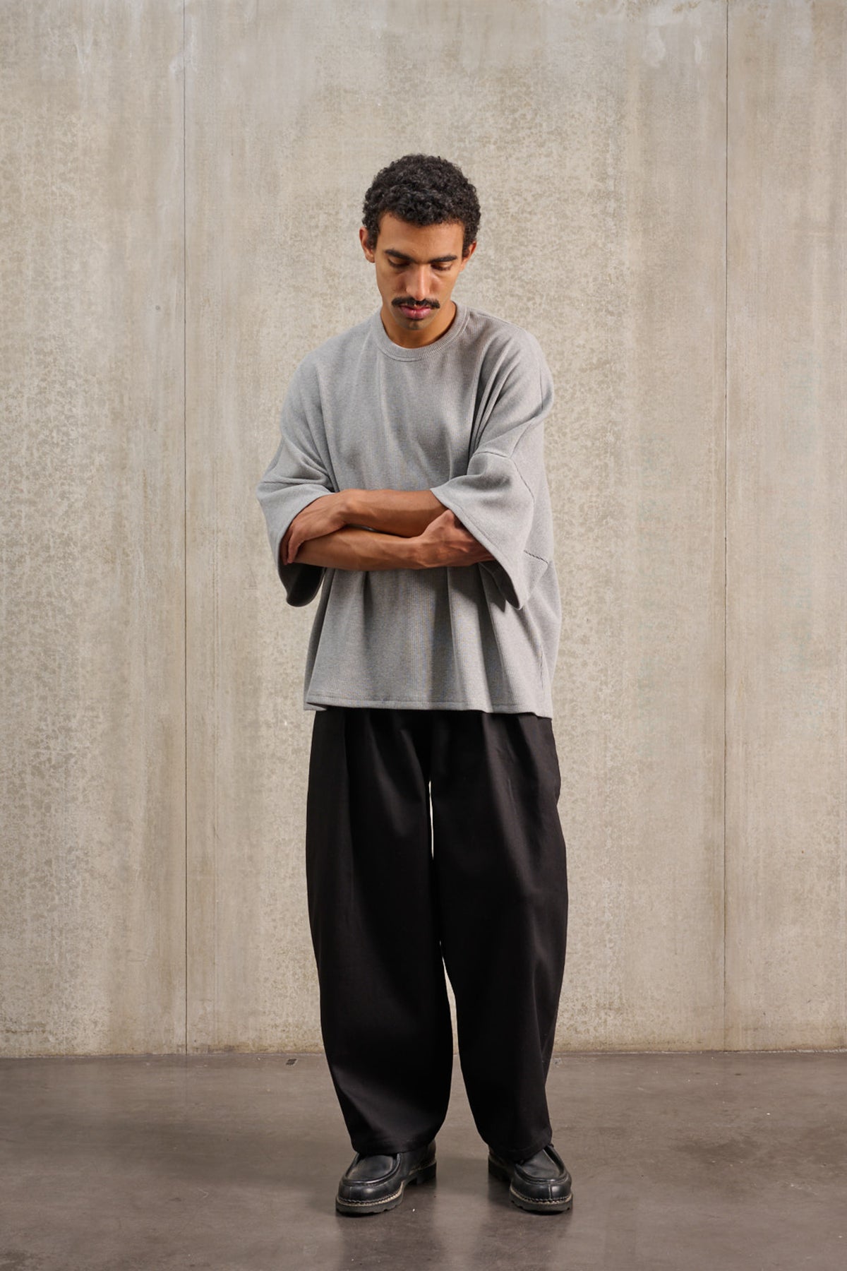 T-shirt oversize à col rond de la marque Aïdama, modèle Haku en jersey côtelé de coton gris chiné. Porté par un mannequin homme et vu de face.