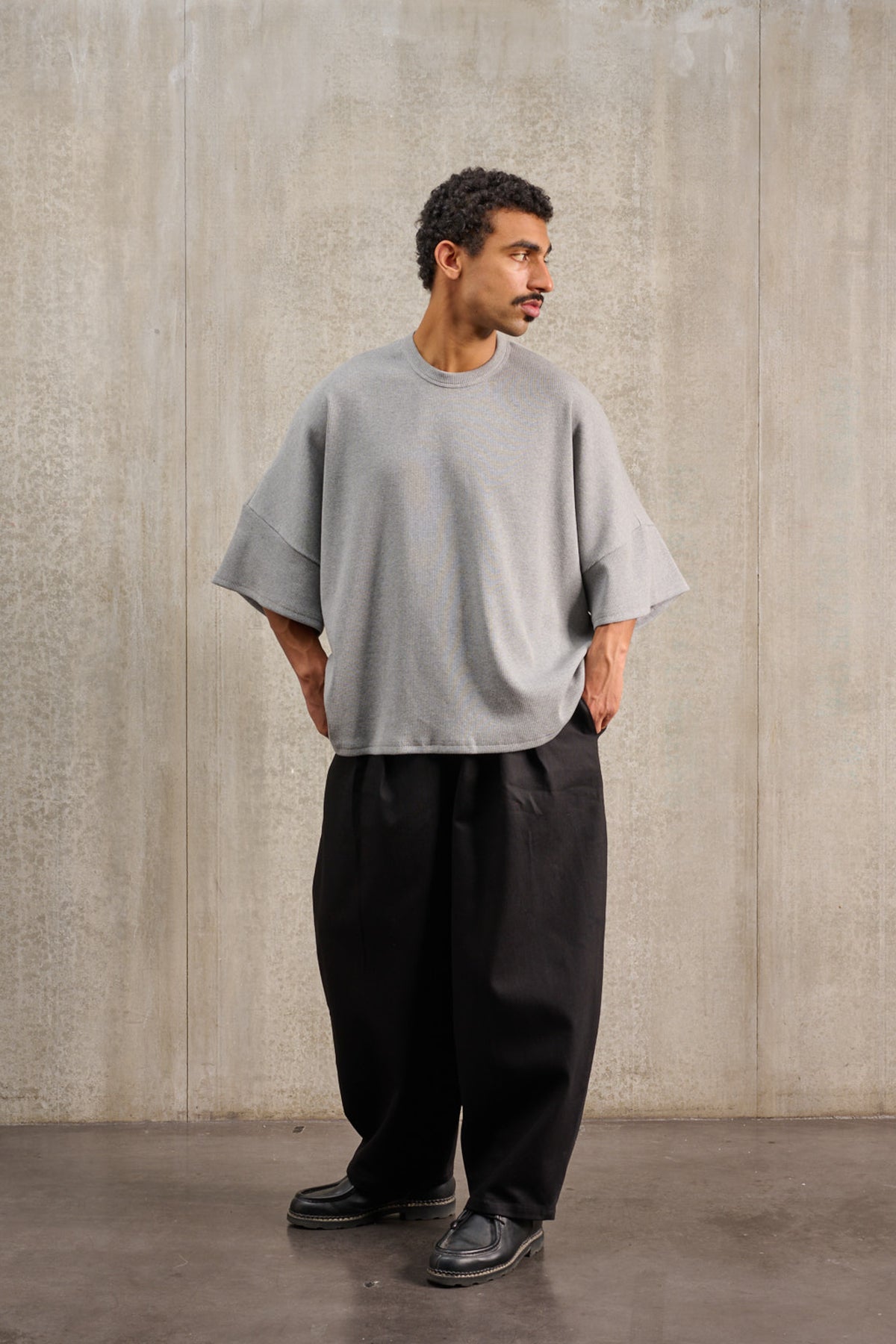 T-shirt oversize à col rond de la marque Aïdama, modèle Haku en jersey côtelé de coton gris chiné. Porté par un mannequin homme et vu de face.
