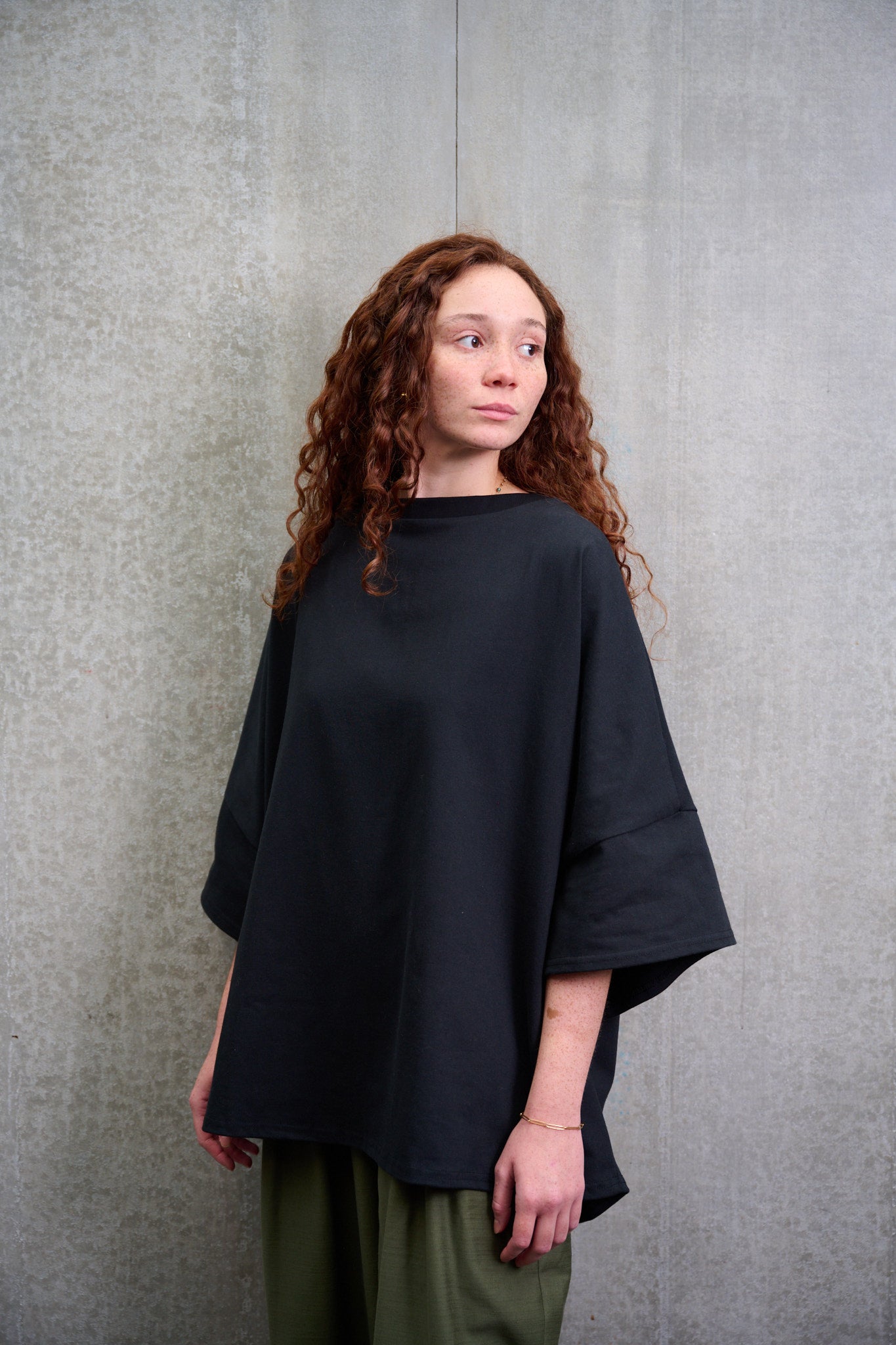 T-shirt oversize à col bateau Haku en coton épais noir de la marque Aïdama. Porté par une mannequin femme et vu de trois quarts.