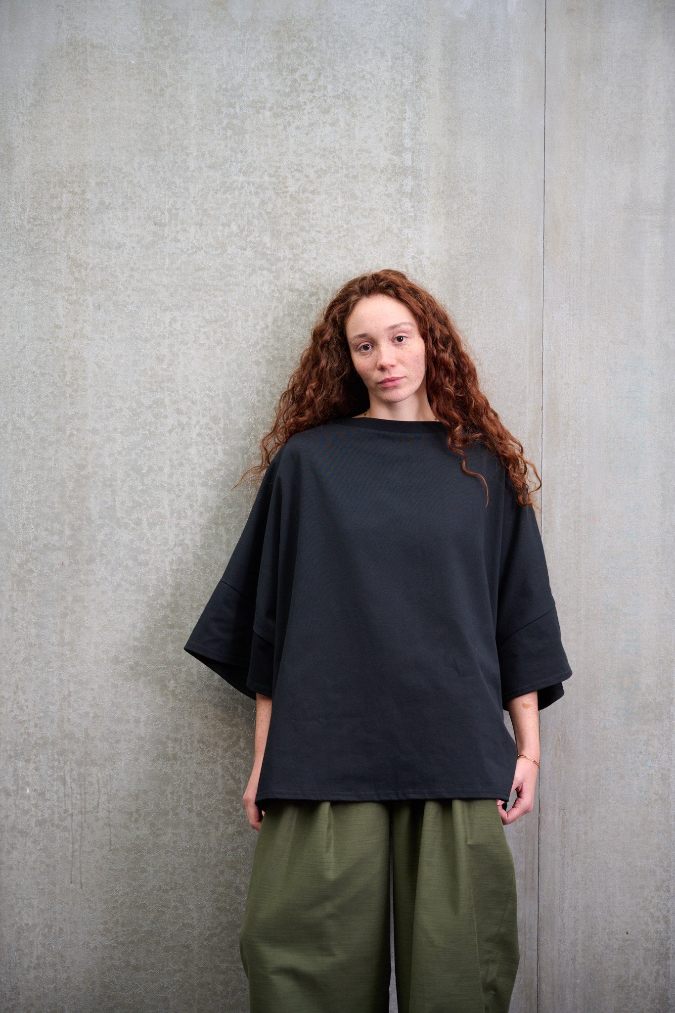 T-shirt oversize à col bateau Haku en coton épais noir de la marque Aïdama. Porté par une mannequin femme et vu de face.