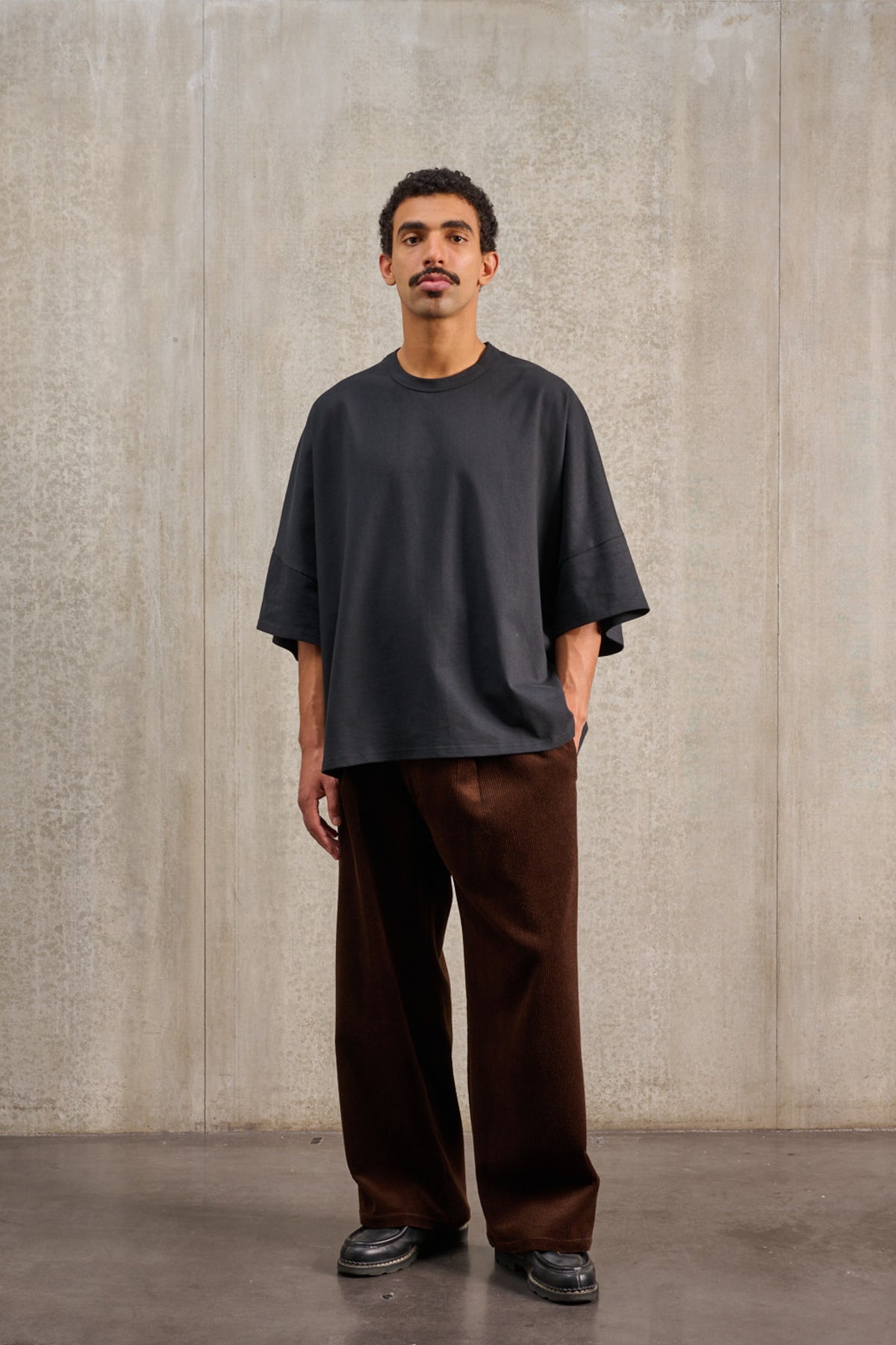 T-shirt oversize à col rond de la marque Aïdama, modèle Haku en jersey de coton noir. Porté par une mannequin femme et vu de face.