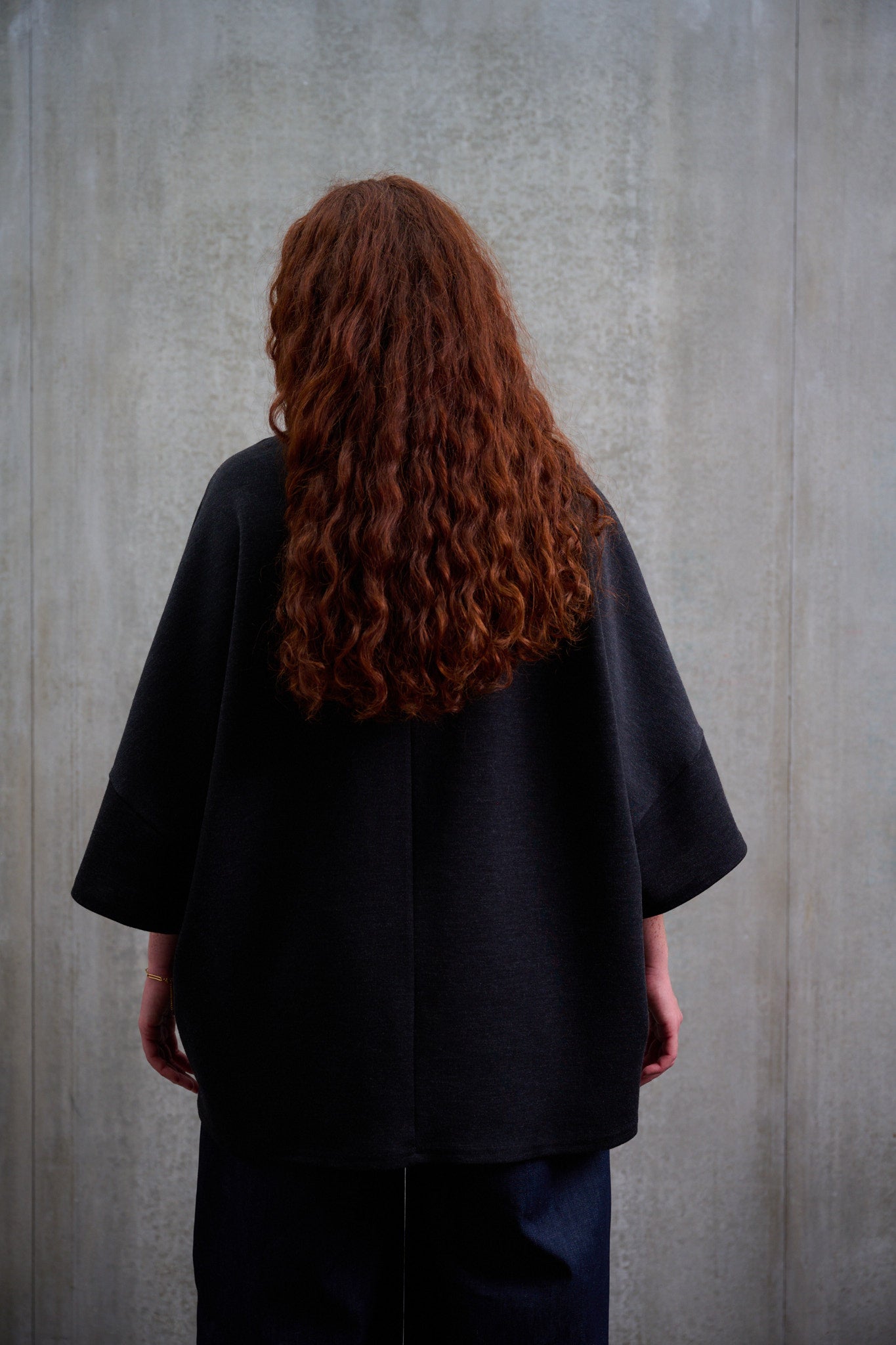 T-shirt oversize à col bateau Haku en laine gris quartz chiné de la marque Aïdama. Porté par une mannequin femme et vu de dos.