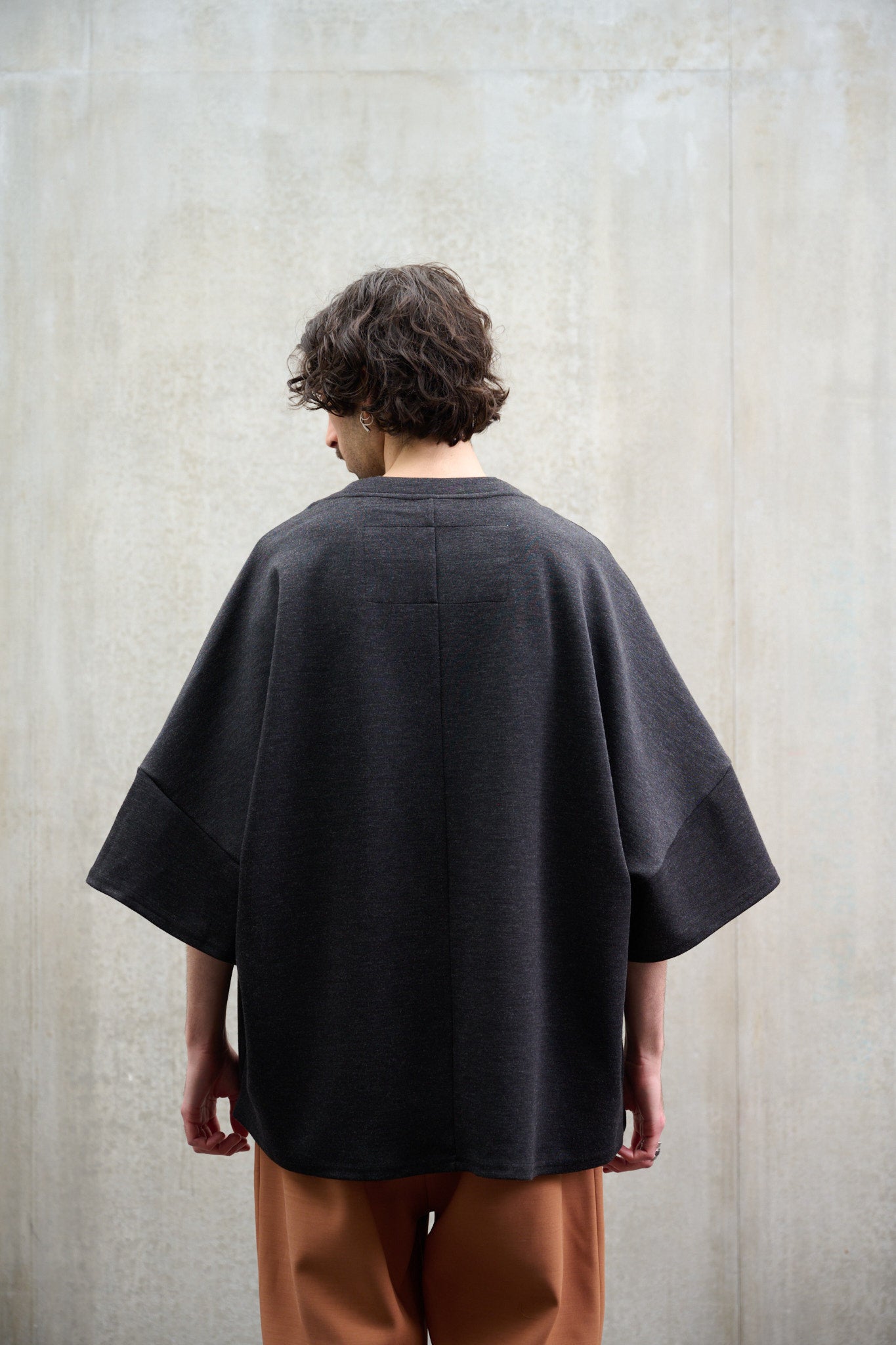 T-shirt oversize à col bateau Haku en laine gris quartz chiné de la marque Aïdama. Porté par un mannequin homme et vu de dos.