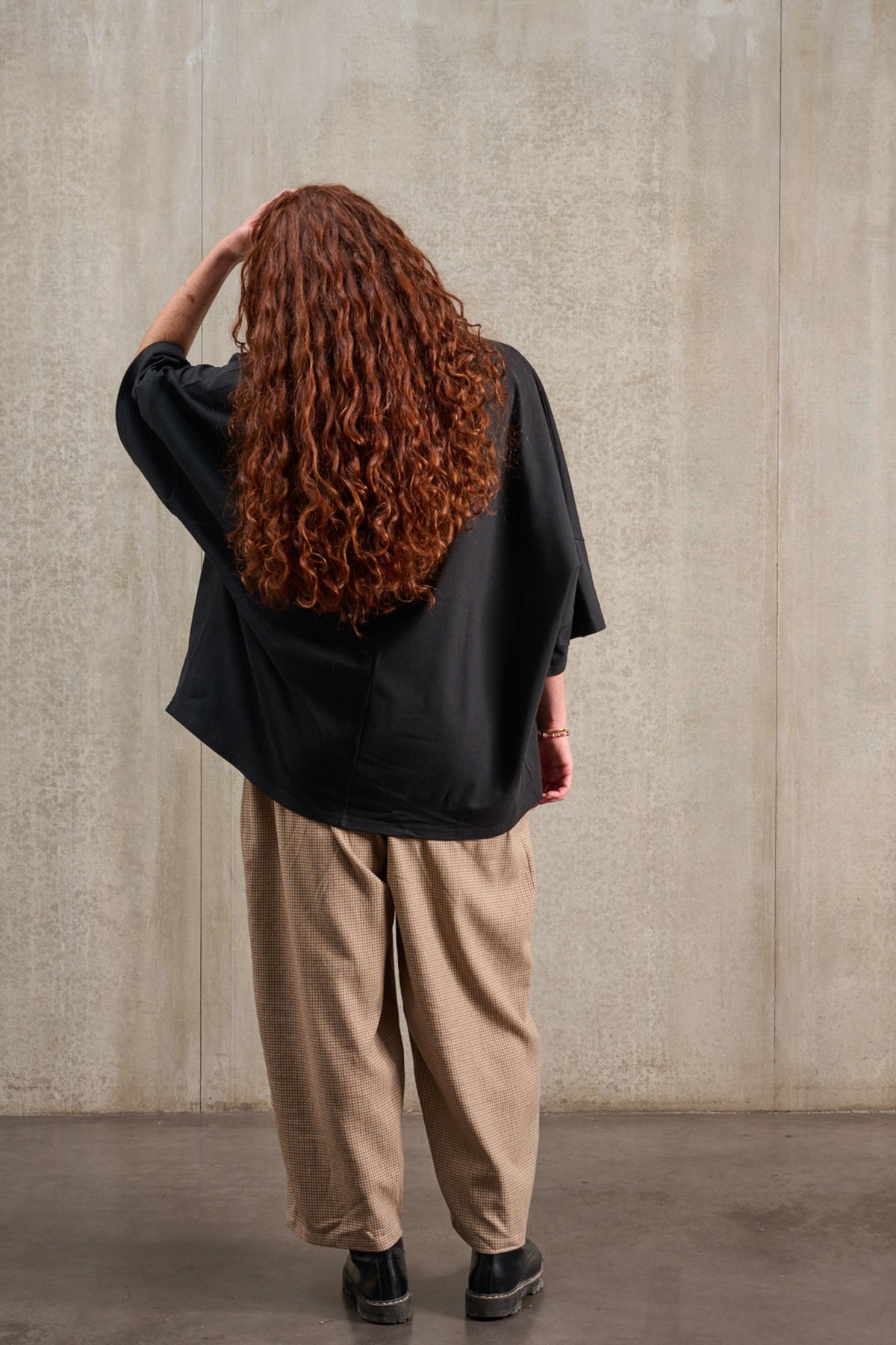 T-shirt oversize à col rond de la marque Aïdama, modèle Haku en jersey de coton noir. Porté par une mannequin femme et vu de dos.