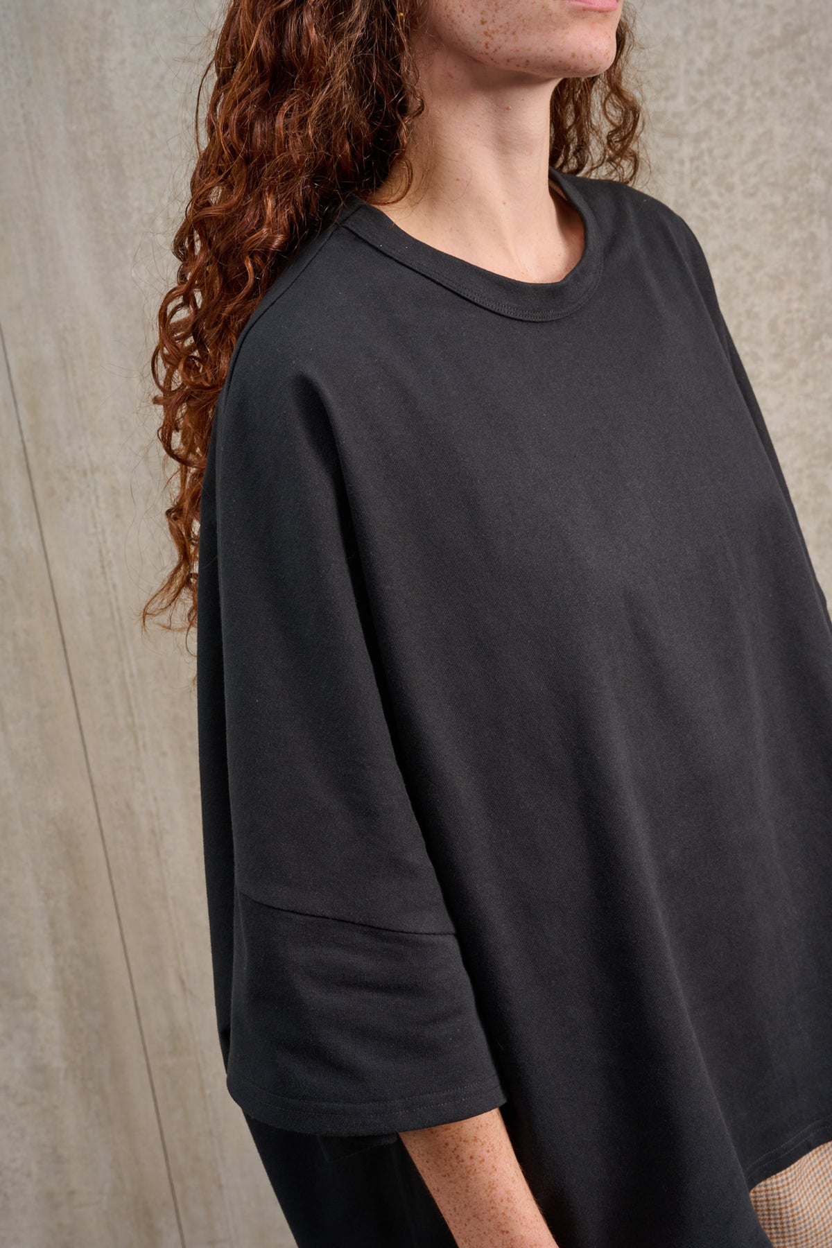 T-shirt oversize à col rond de la marque Aïdama, modèle Haku en jersey de coton noir. Porté par une mannequin femme et vu centré sur le buste.