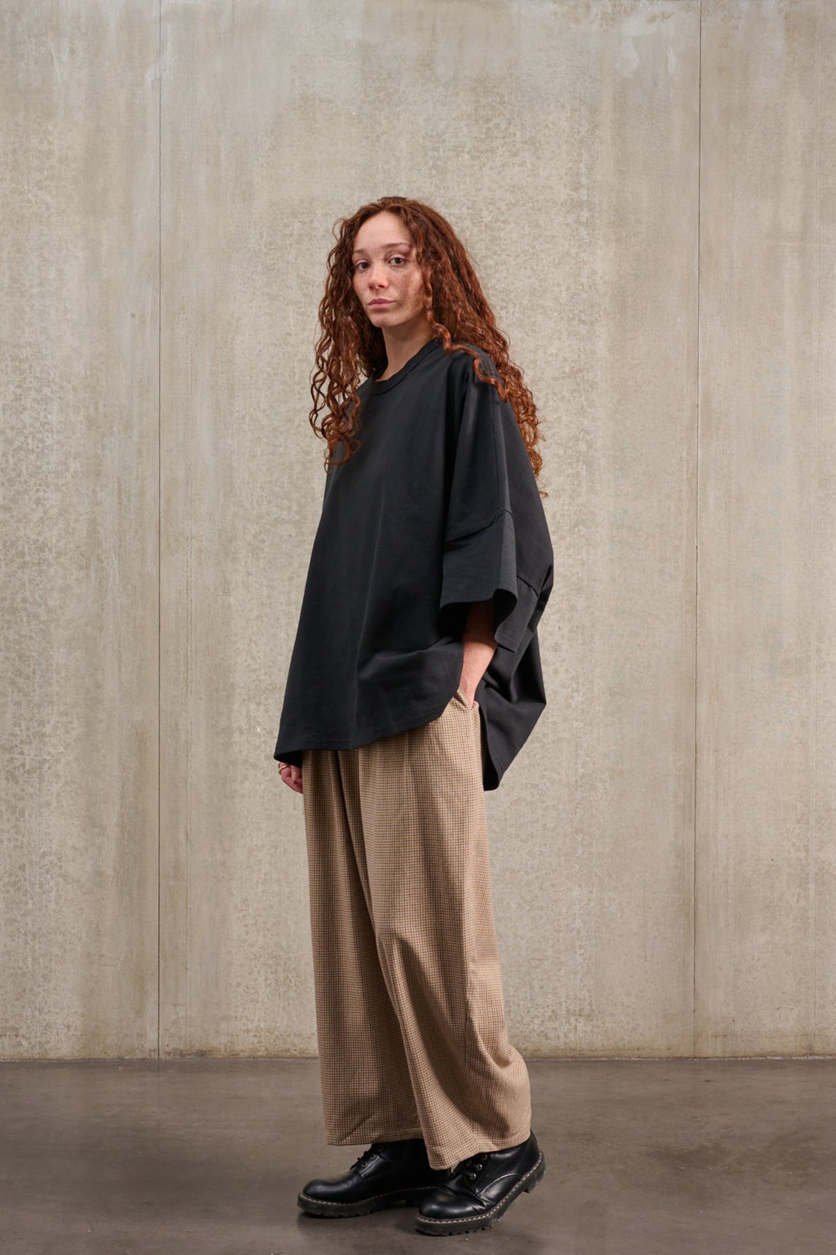 T-shirt oversize à col rond de la marque Aïdama, modèle Haku en jersey de coton noir. Porté par une mannequin femme et vu de trois quarts.