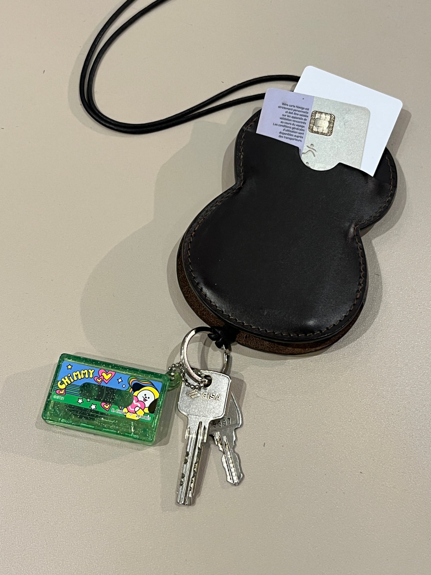 Tour de cou porte-cartes et porte-clés Hyotan de la marque Aïdama en cuir de vachette marron foncé. Posé et vu face verso avec les cartes ajoutées et les clés accrochées.