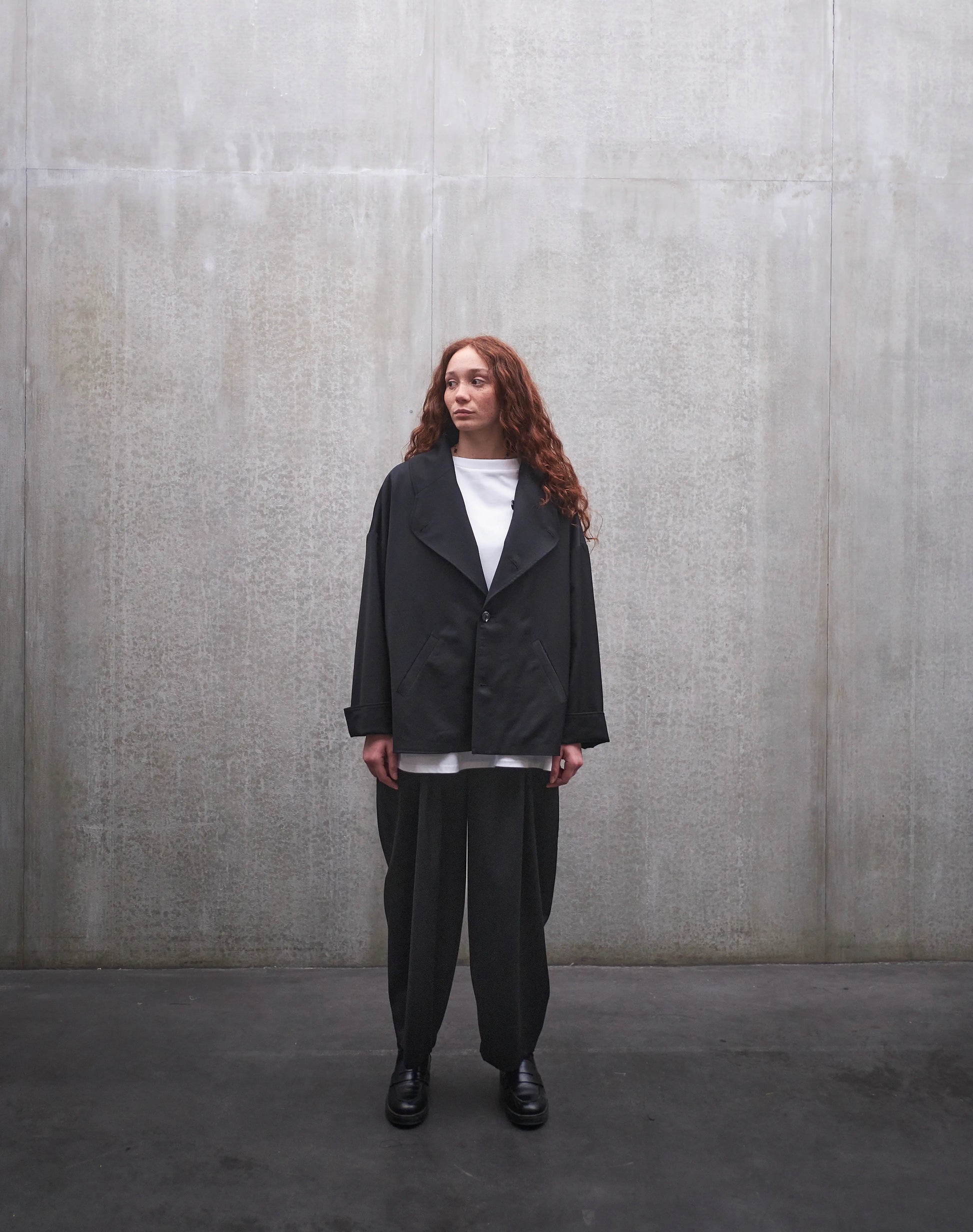 Veste oversize Aïdama, modèle Gunbai en laine froide noire. Portée fermée par une mannequin femme et vue de face.