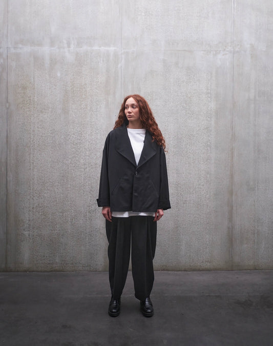 Veste oversize Aïdama, modèle Gunbai en laine froide noire. Portée fermée par une mannequin femme et vue de face.