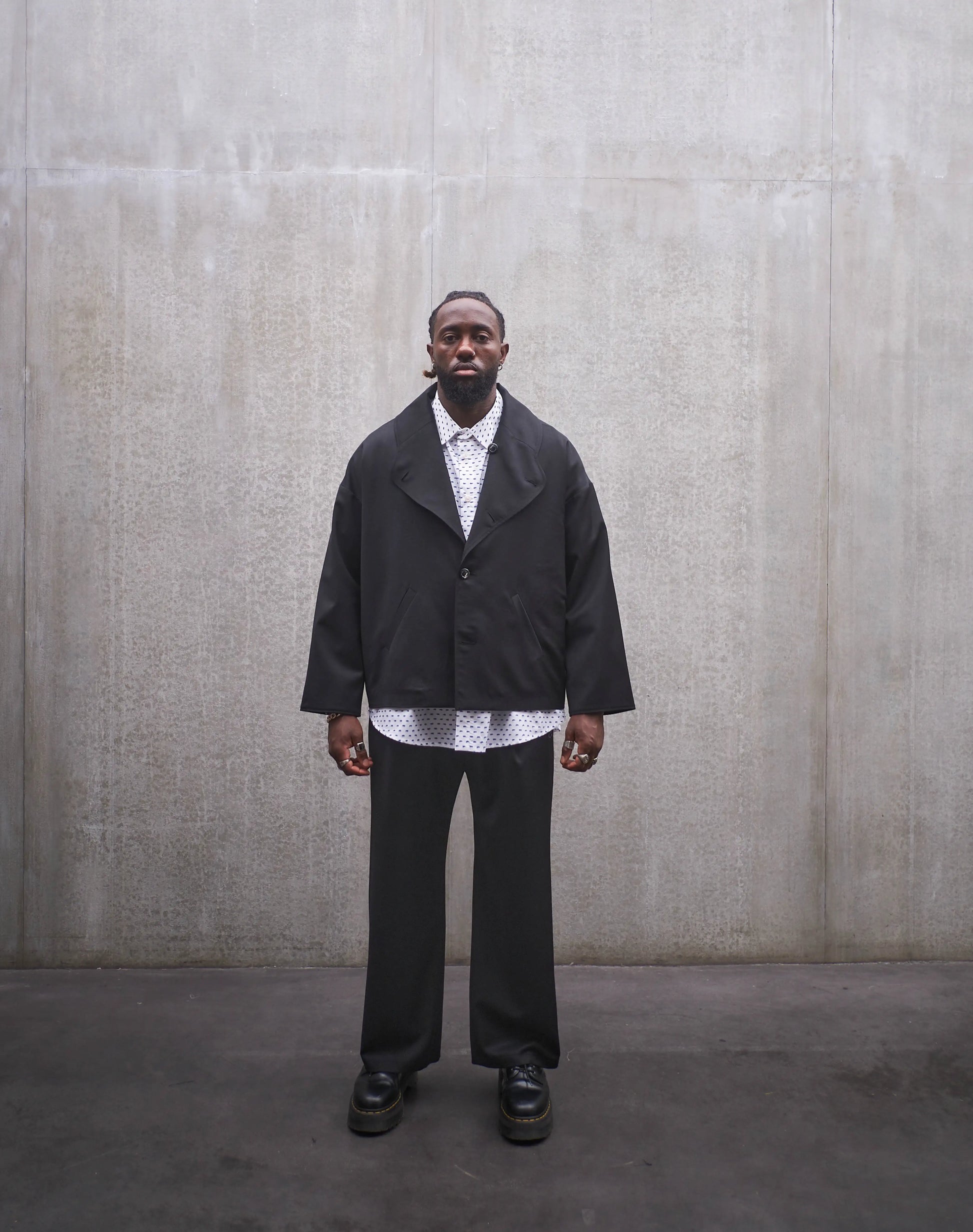 Veste oversize Aïdama, modèle Gunbai en laine froide noire. Portée fermée par un mannequin homme et vue de face.