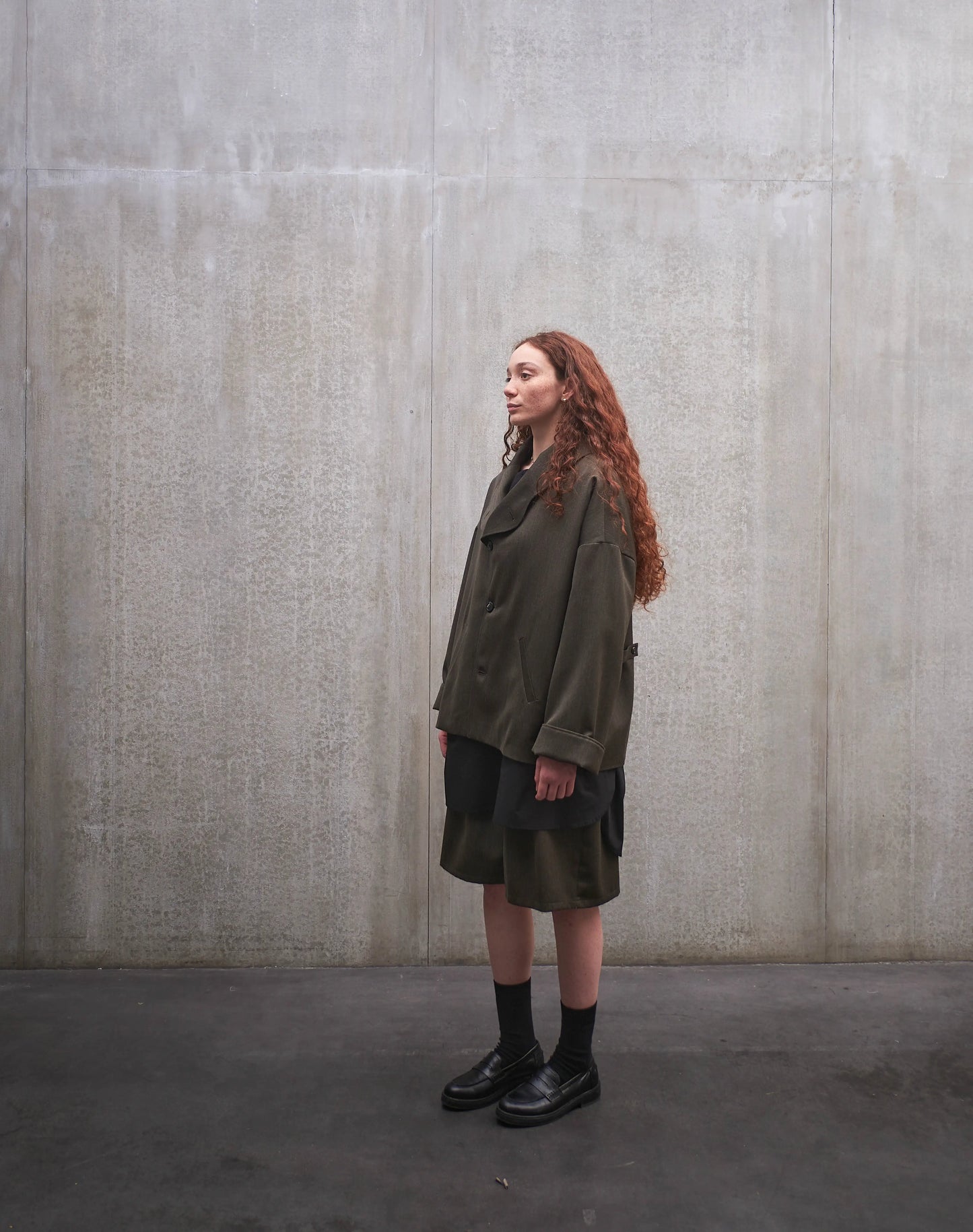 Veste oversize Aïdama, modèle Gunbai en laine froide vert chiné. Portée fermée par une mannequin femme et vue de trois quarts.