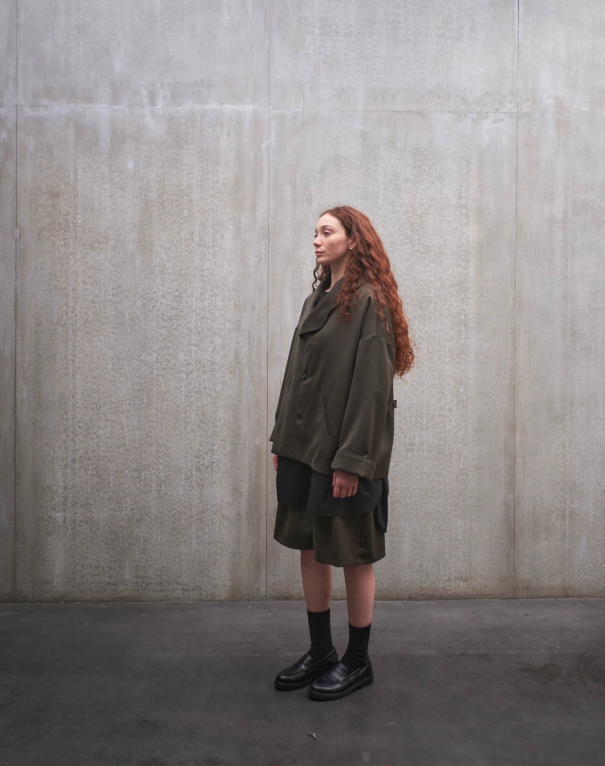Veste oversize Aïdama, modèle Gunbai en laine froide vert chiné. Portée fermée par une mannequin femme et vue de trois quarts.