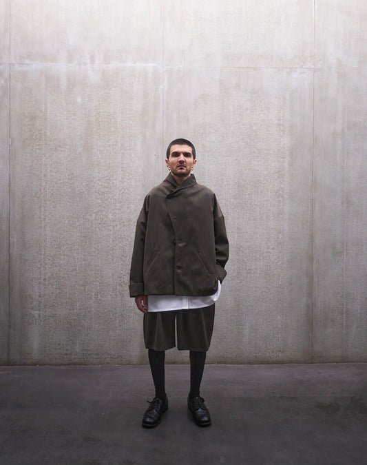 Veste oversize Aïdama, modèle Gunbai en laine froide vert chiné. Portée fermée par un mannequin homme et vue de face.