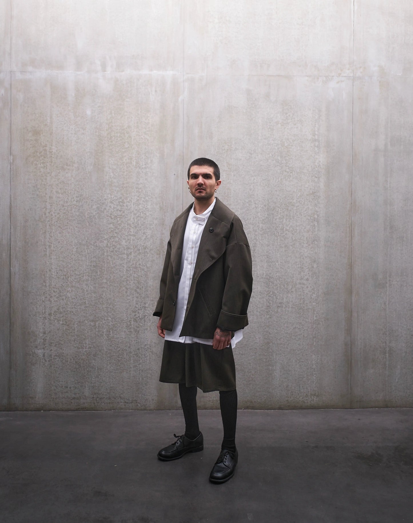 Veste oversize Aïdama, modèle Gunbai en laine froide vert chiné. Portée ouverte par un mannequin homme et vue de face.