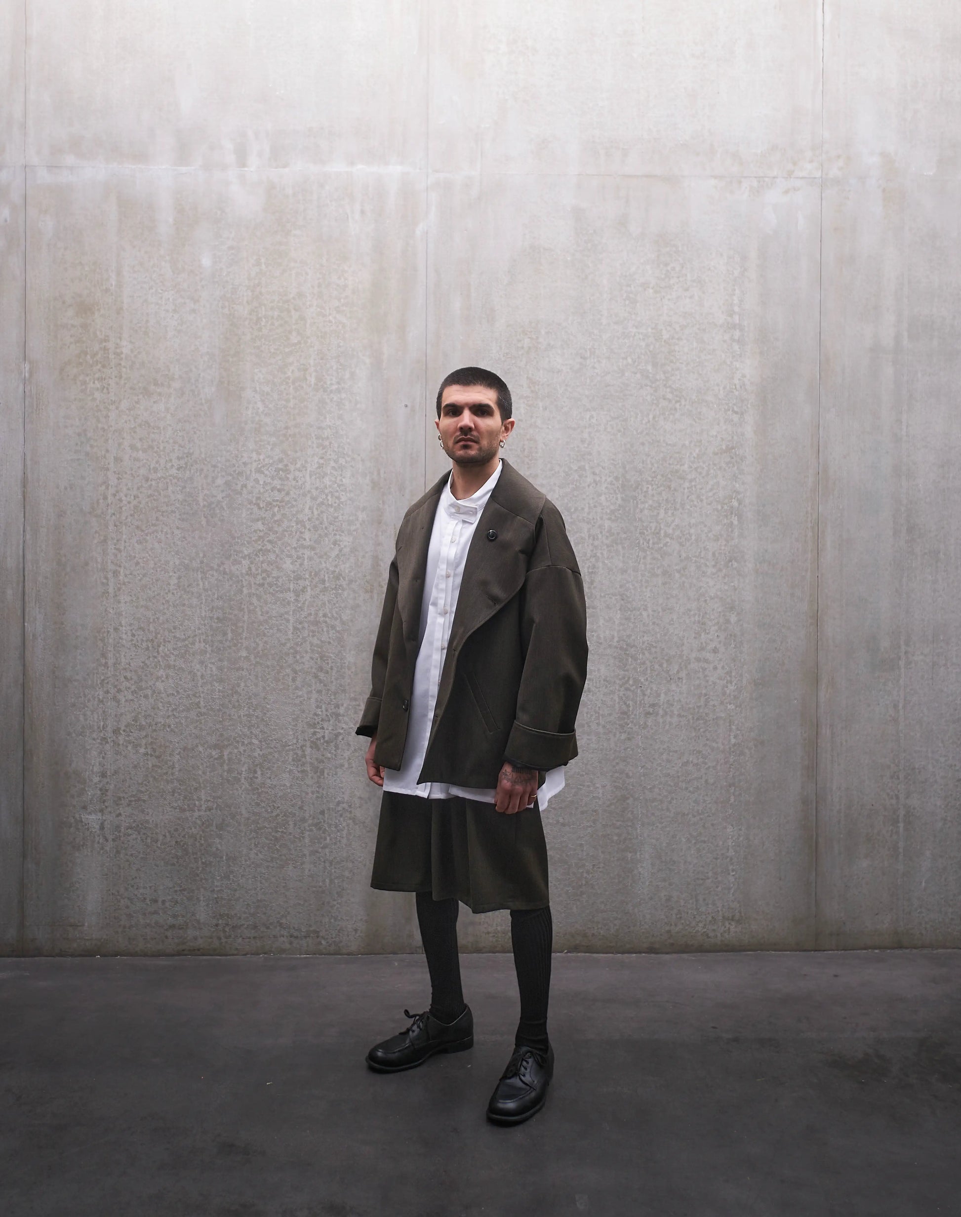 Veste oversize Aïdama, modèle Gunbai en laine froide vert chiné. Portée ouverte par un mannequin homme et vue de face.