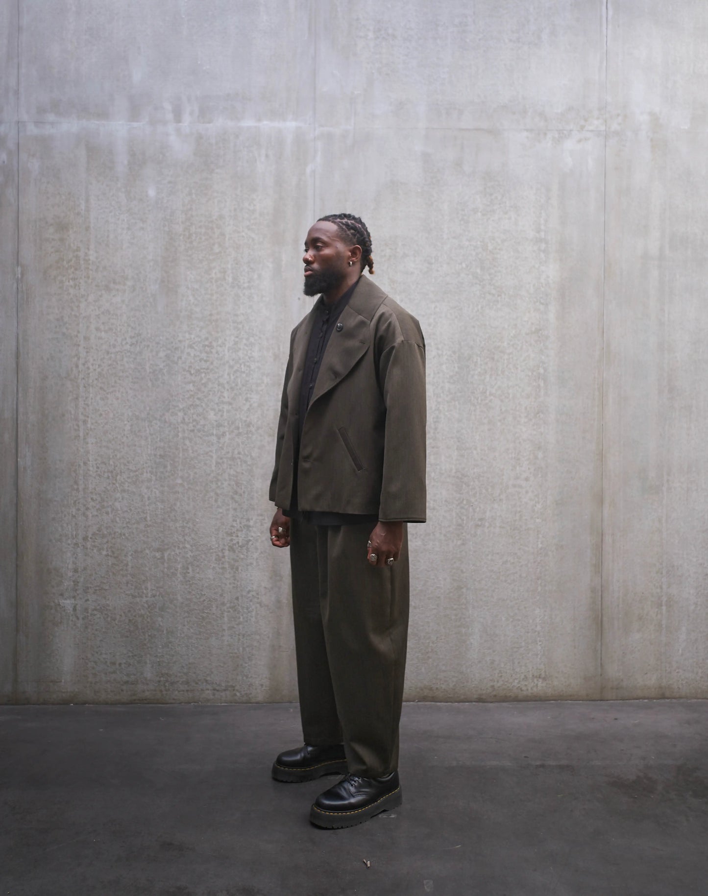 Veste oversize Aïdama, modèle Gunbai en laine froide vert chiné. Portée ouverte par un mannequin homme et vue de trois quarts.