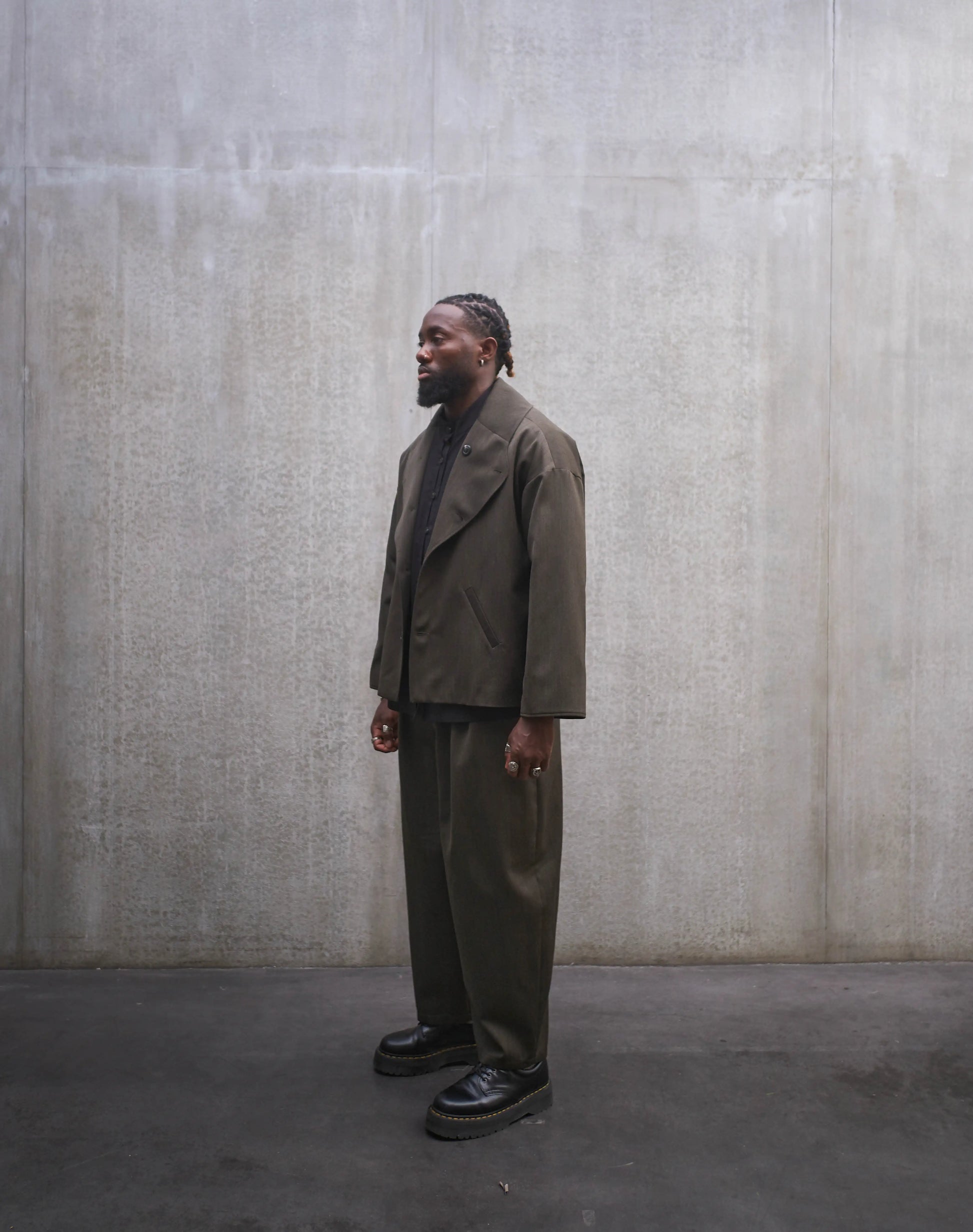 Veste oversize Aïdama, modèle Gunbai en laine froide vert chiné. Portée ouverte par un mannequin homme et vue de trois quarts.
