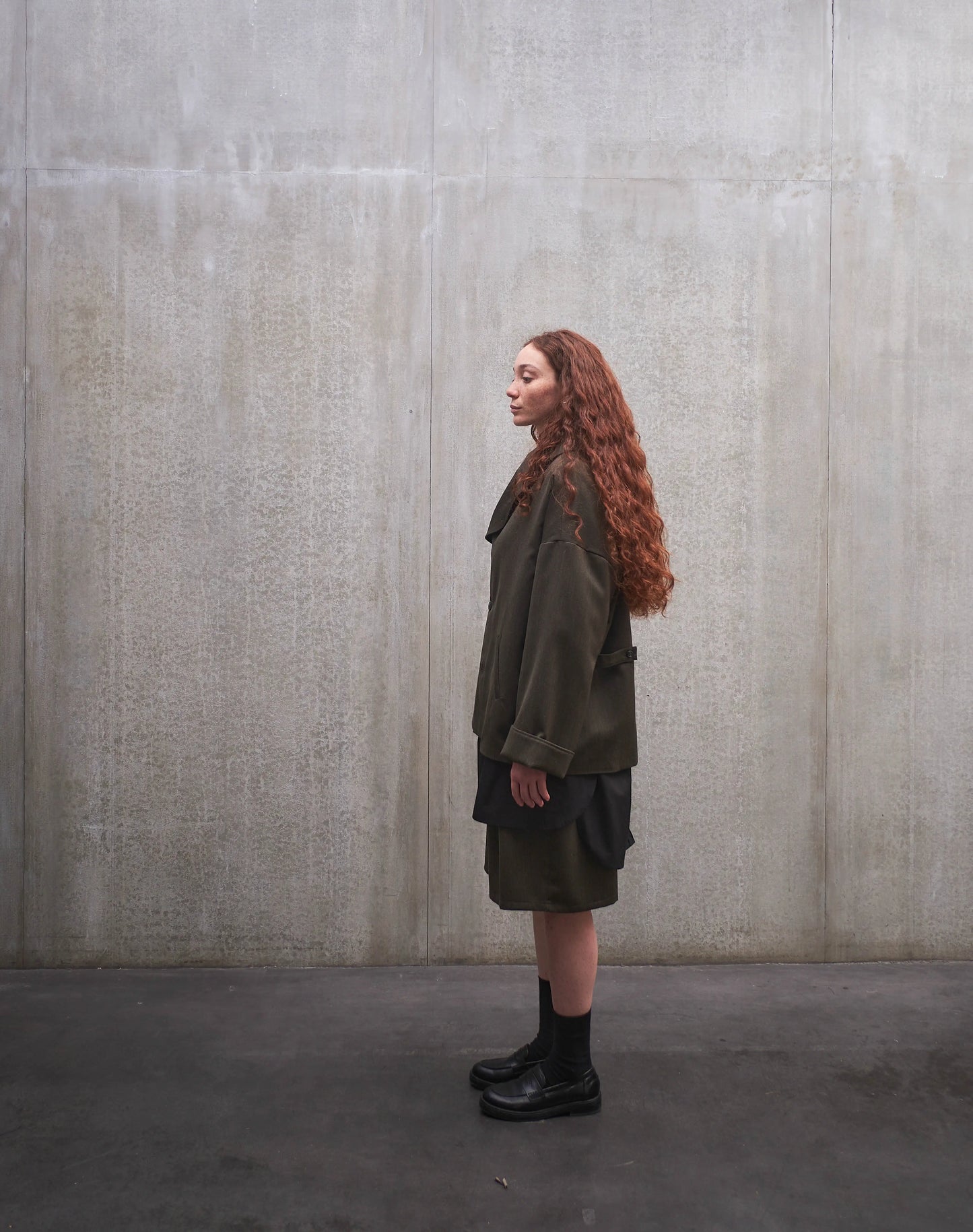 Veste oversize Aïdama, modèle Gunbai en laine froide vert chiné. Portée ouverte par une mannequin femme et vue de profil.