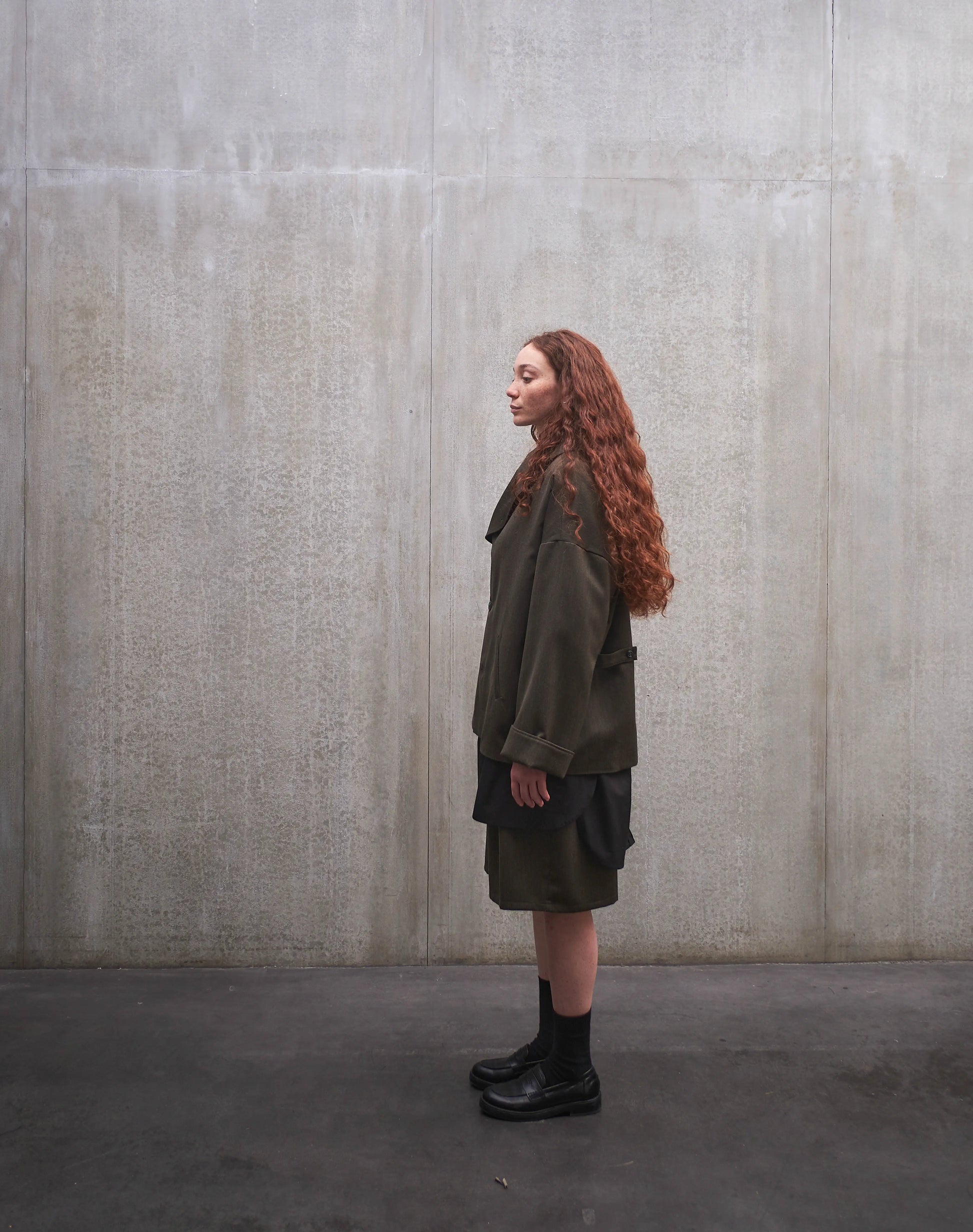 Veste oversize Aïdama, modèle Gunbai en laine froide vert chiné. Portée ouverte par une mannequin femme et vue de profil.