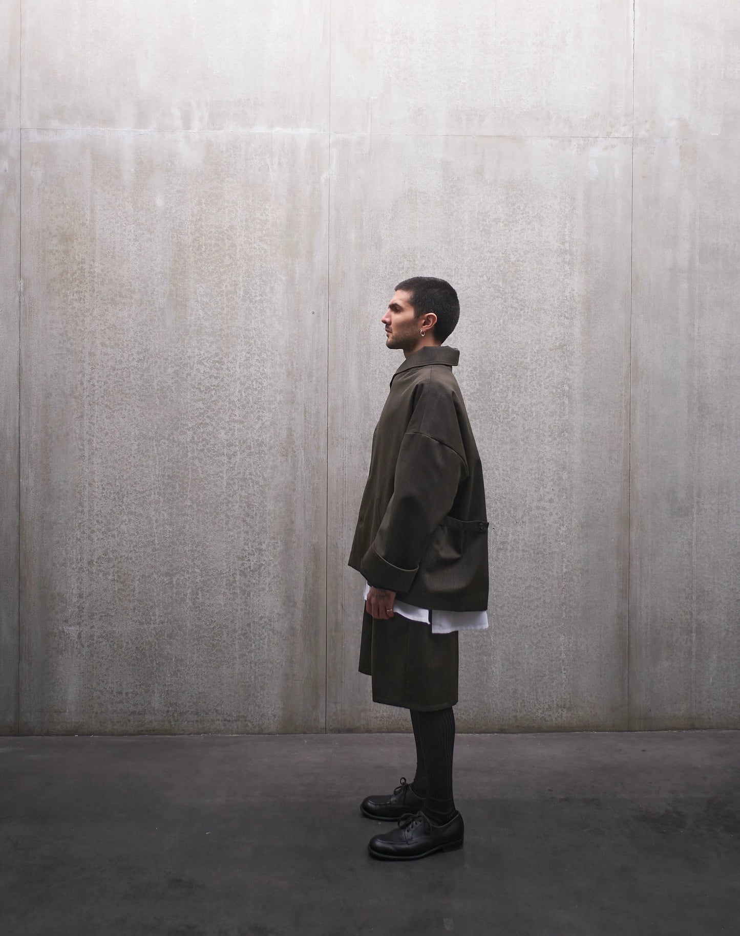 Veste oversize Aïdama, modèle Gunbai en laine froide vert chiné. Portée fermée par un mannequin homme et vue de profil.