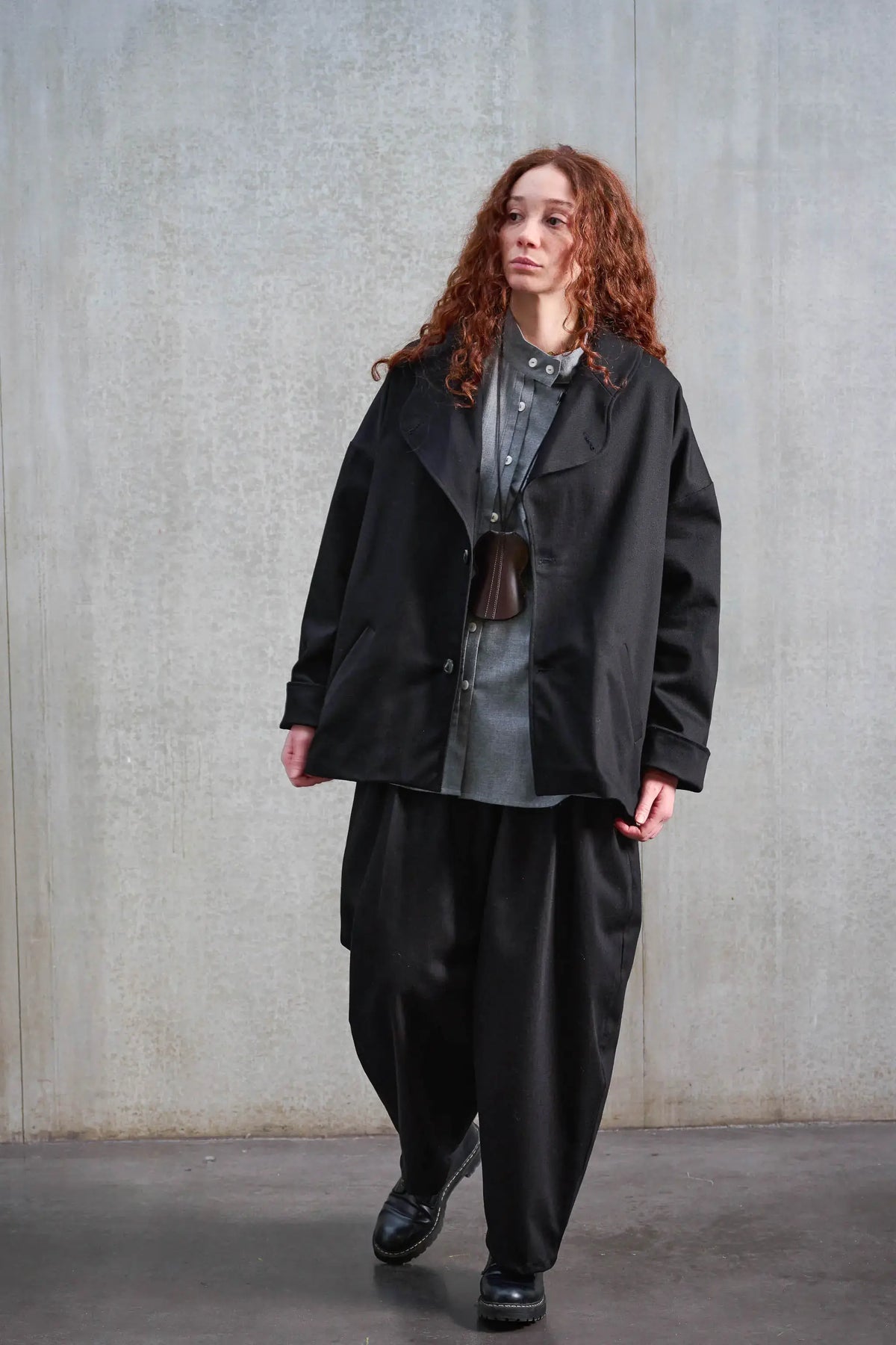 Veste oversize de la marque Aïdama, modèle Gunbai en sergé de coton noir. Portée par une mannequin femme et vue de face, ouverte.