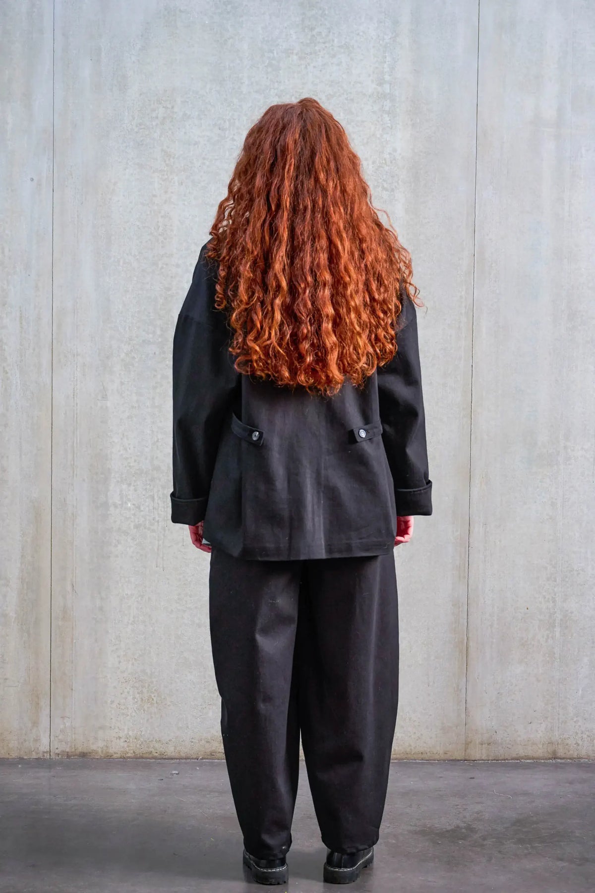 Veste oversize de la marque Aïdama, modèle Gunbai en sergé de coton noir. Portée par une mannequin femme et vue de dos.