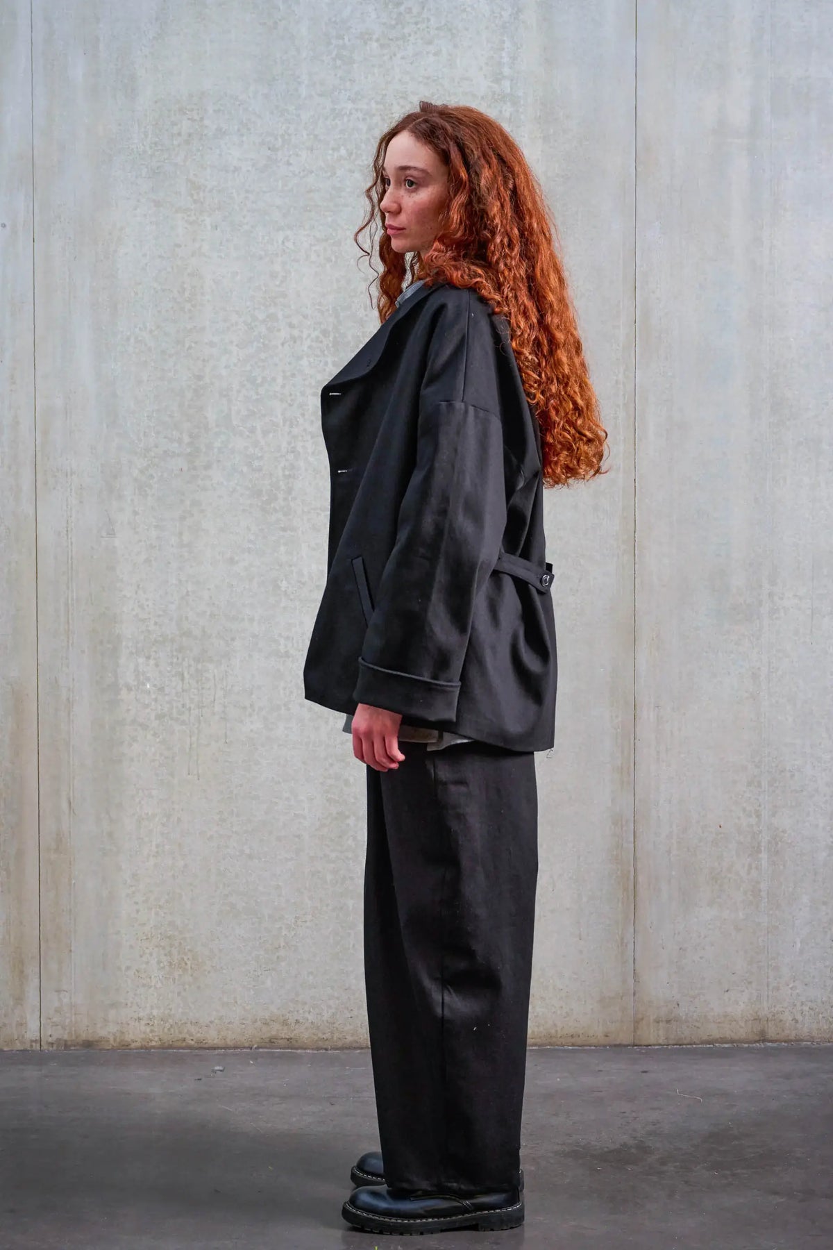 Veste oversize de la marque Aïdama, modèle Gunbai en sergé de coton noir. Portée ouverte par un mannequin homme et vue de profil.