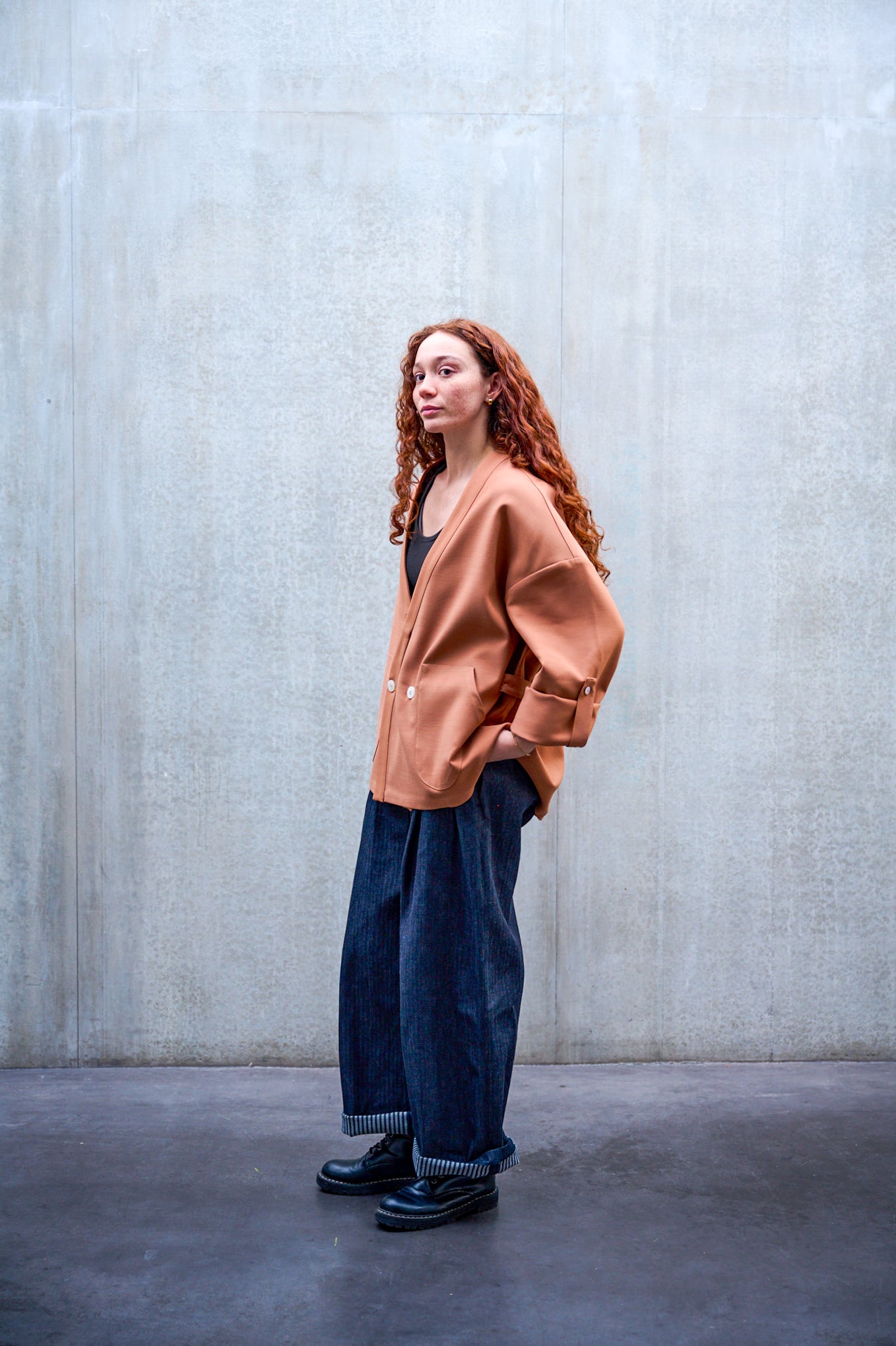 Veste croisée à col kimono Aïdama modèle samue en double face de laine et coton terre de sienne. Portée fermée par une mannequin femme et vue de profil. 