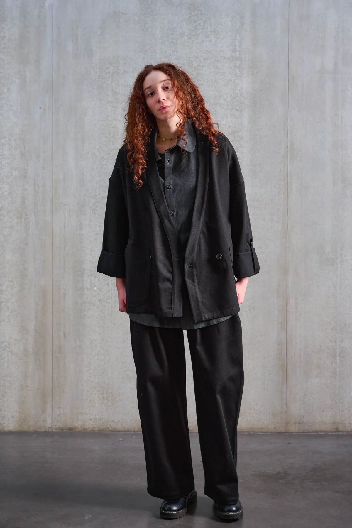Veste oversize à col kimono de la marque Aïdama, modèle Samue en sergé de coton noir. Portée ouverte par une mannequin femme et vue de face.