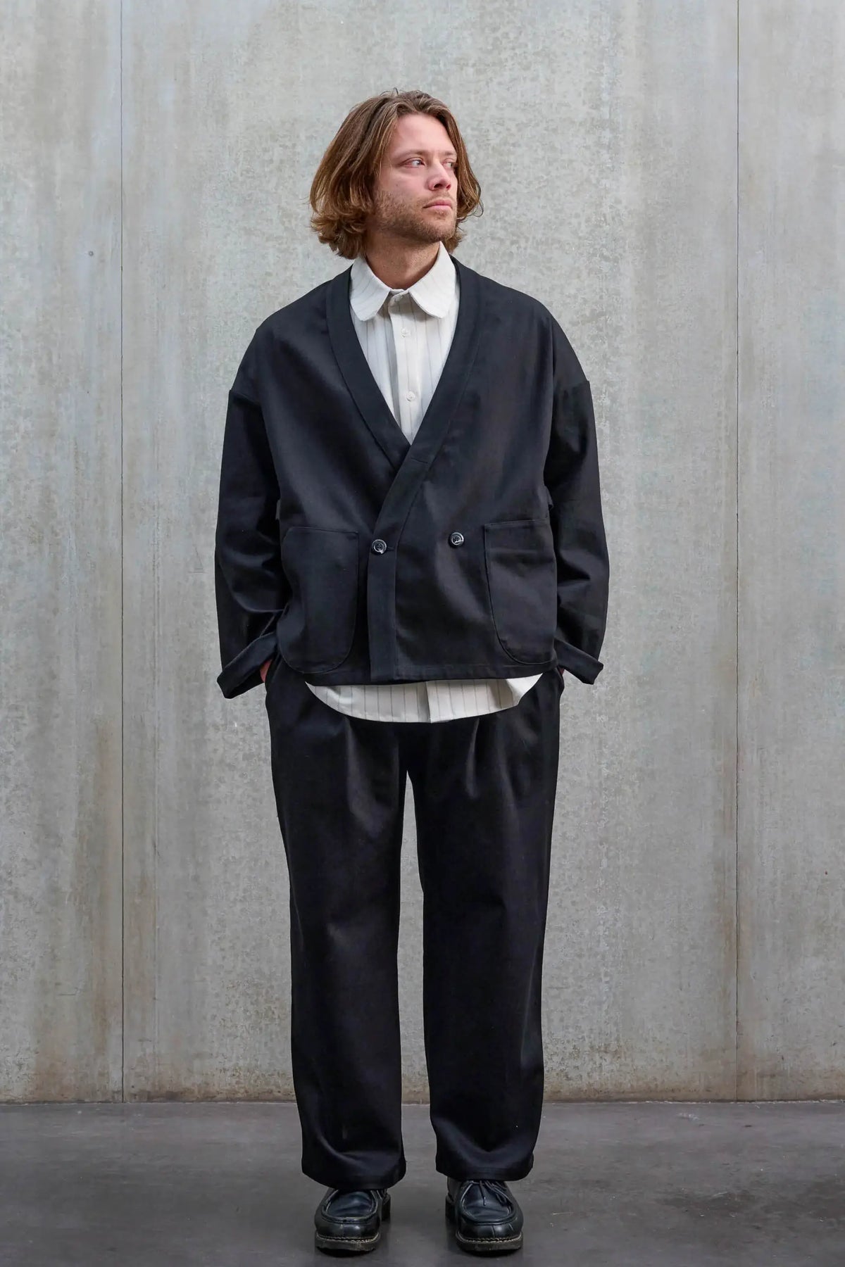 Veste oversize à col kimono de la marque Aïdama, modèle Samue en sergé de coton noir. Portée fermée par un mannequin homme et vue de face.