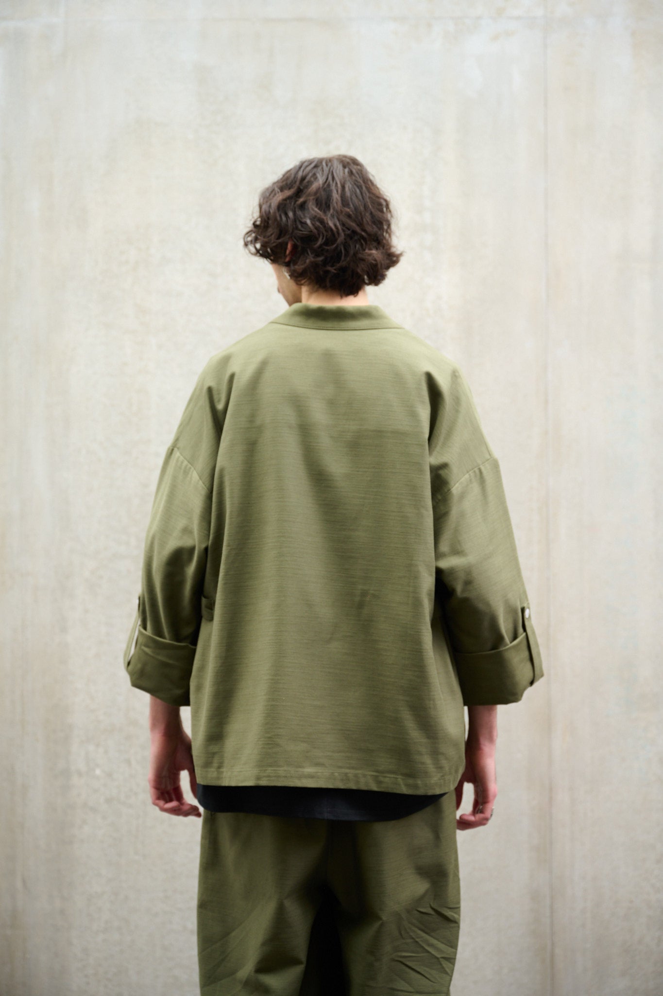 Veste croisée à col kimono Aïdama modèle samue en coton vert texturé. Portée par un mannequin homme et vue de dos.