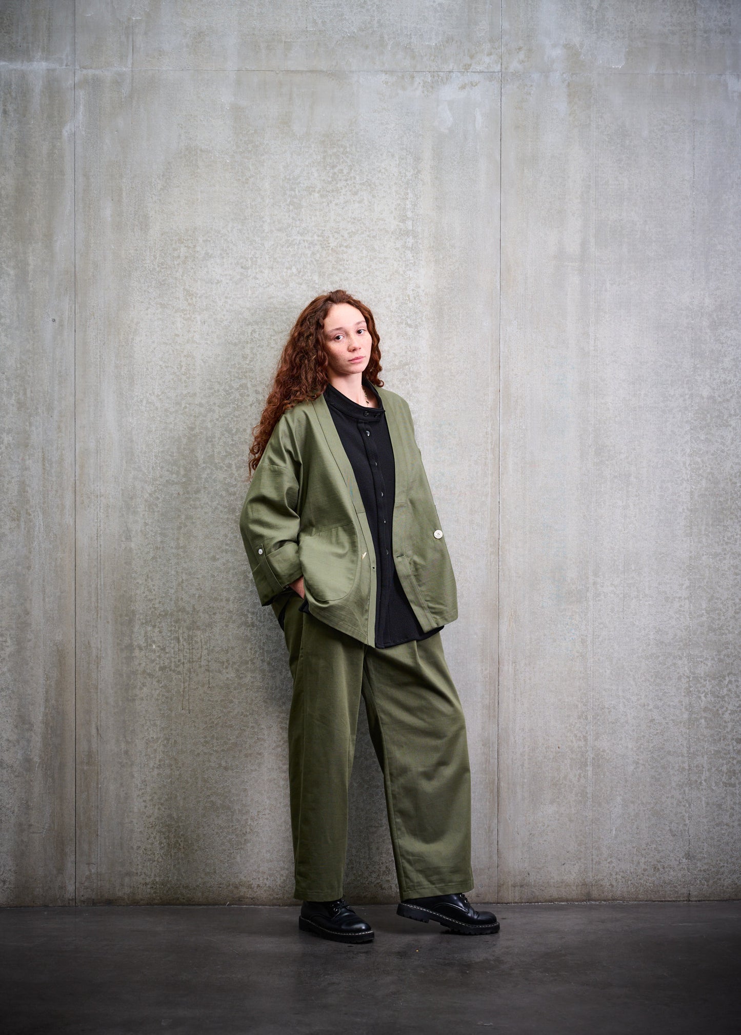 Veste croisée à col kimono Aïdama modèle samue en coton vert texturé. Portée ouverte par une mannequin femme et vue de face.