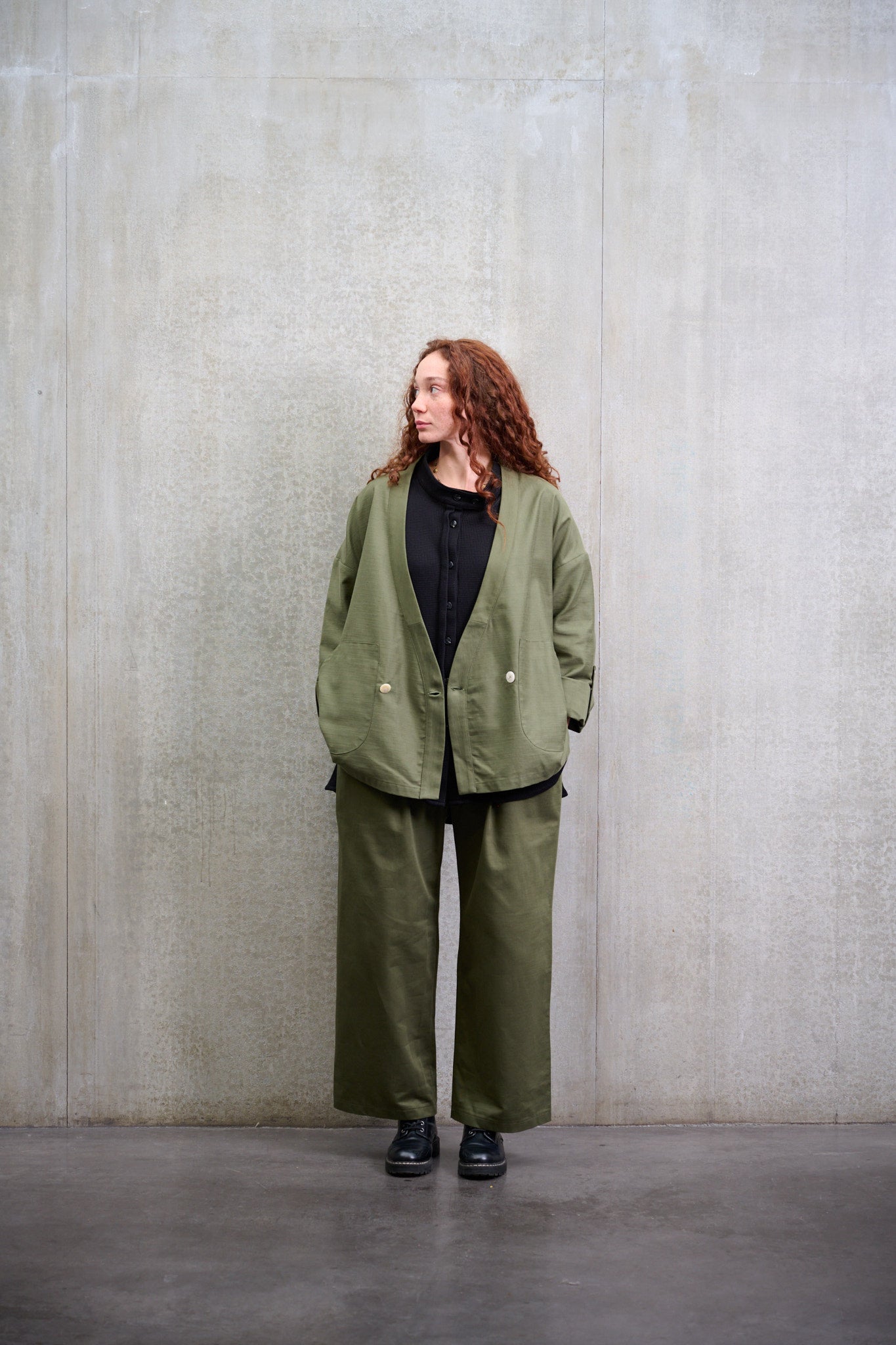Veste croisée à col kimono Aïdama modèle samue en coton vert texturé. Portée ouverte par une mannequin femme et vue zoomée sur la manche.