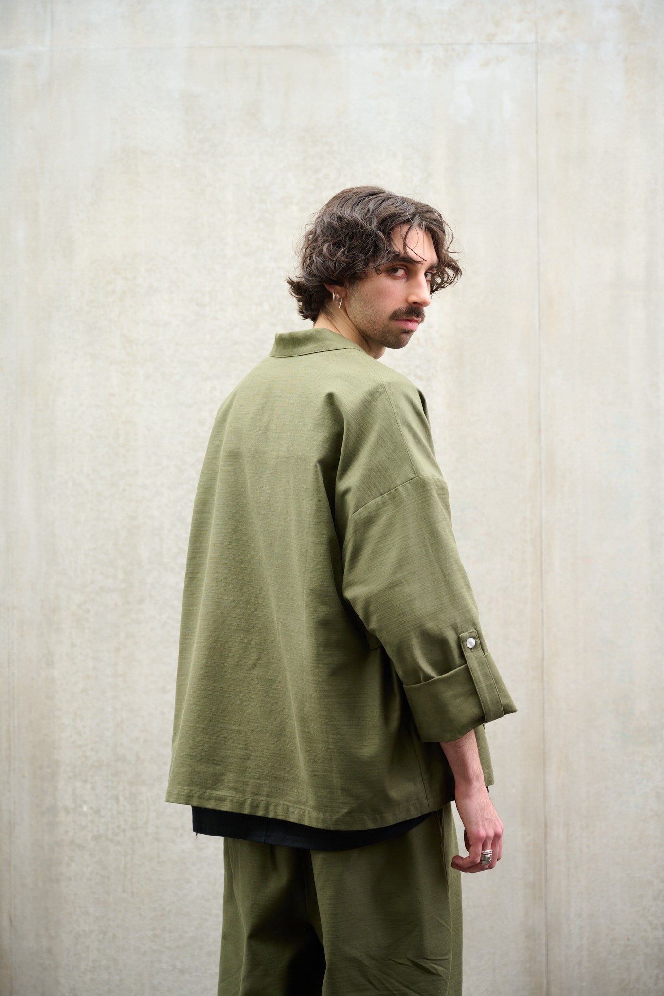 Veste croisée à col kimono Aïdama modèle samue en coton vert texturé. Portée fermée par un mannequin homme et vue de dos.
