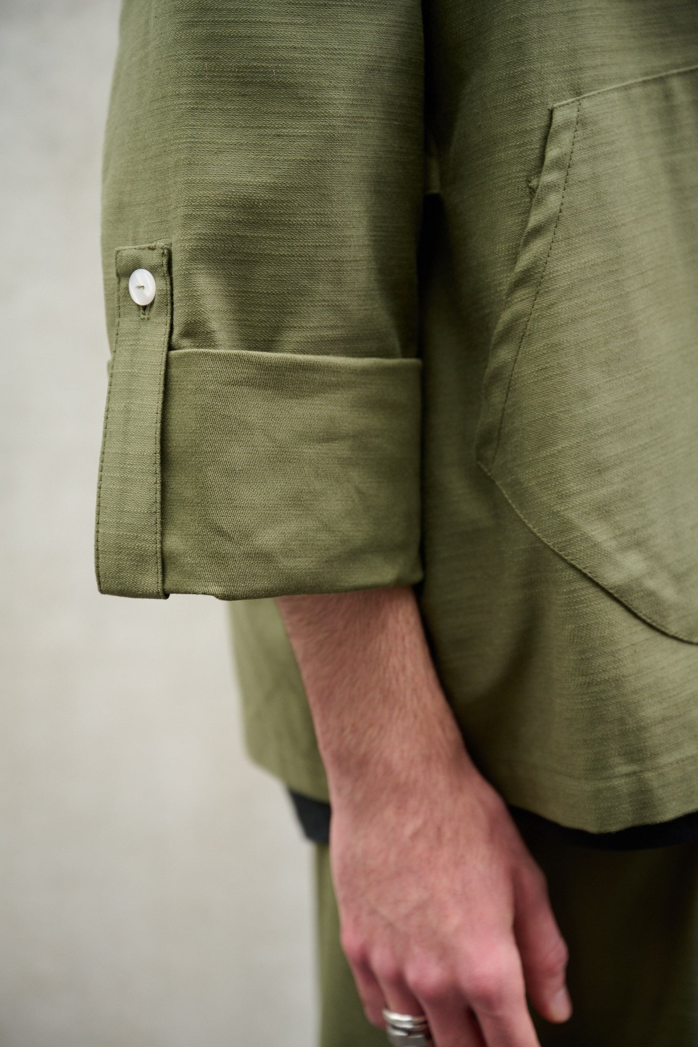Veste croisée à col kimono Aïdama modèle samue en coton vert texturé. Portée par un mannequin homme et vue zoomée sur la manche.