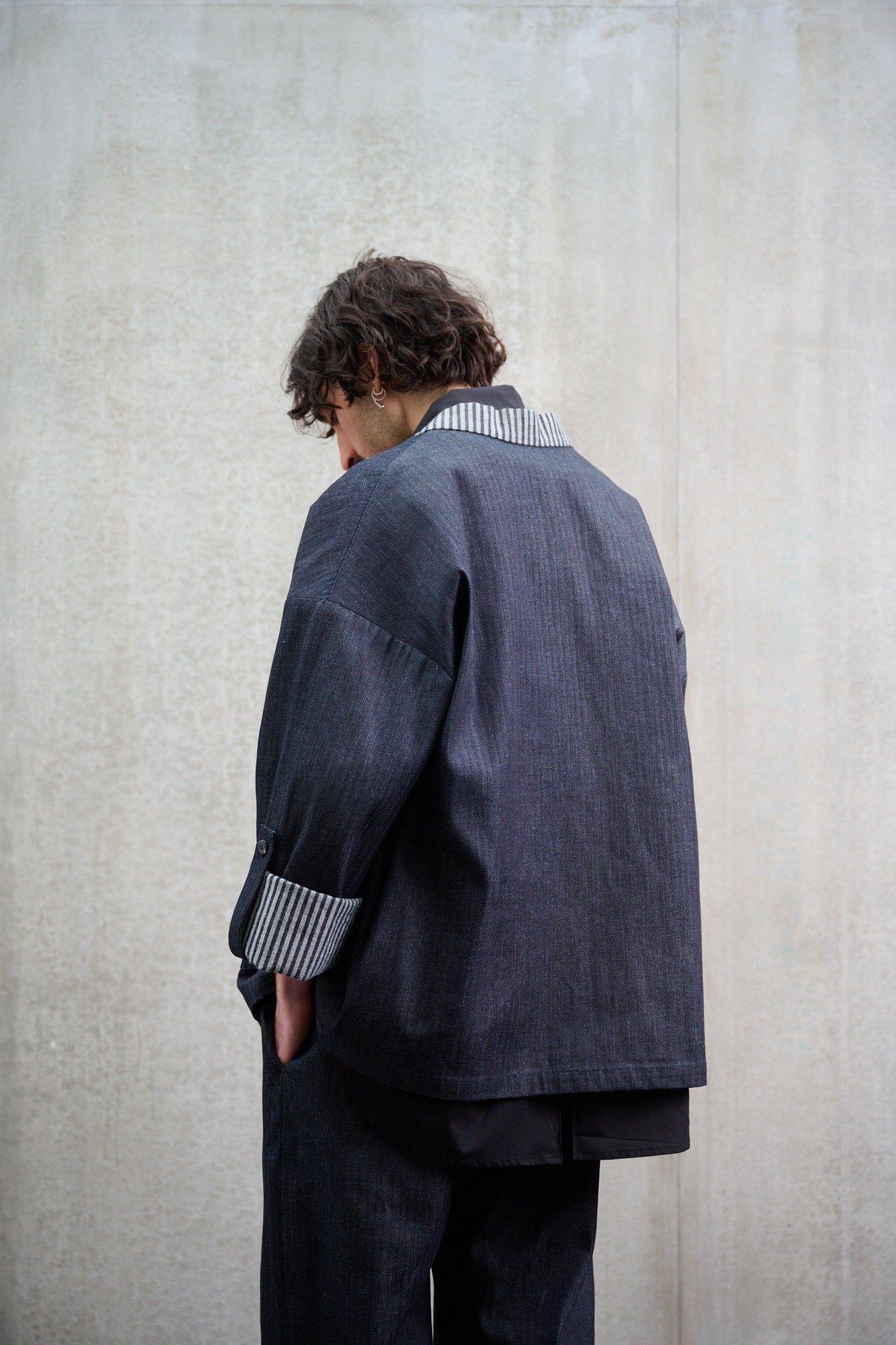Veste croisée à col kimono Aïdama modèle Samue en denim japonais rayé. Portée par un mannequin homme et vue de dos.